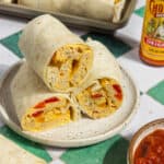 A plate with stacked breakfast burritos.