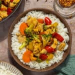 A bowl of white rice topped with chicken cashew stir fry.