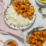 Two plated dishes of honey lime shrimp with coconut rice.