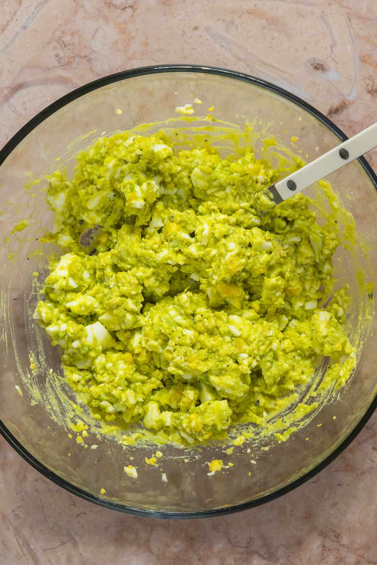 Mashed avocado and mashed hardboiled egg mixed together.