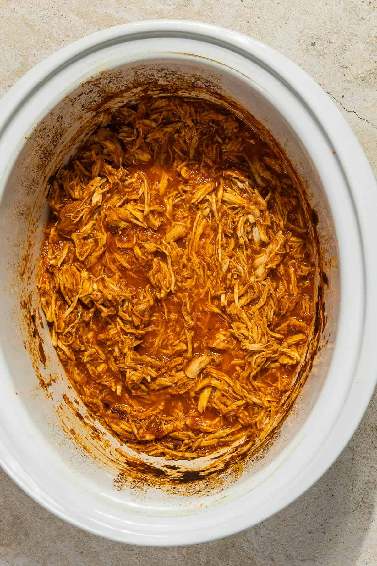 A crockpot with shredded chicken tinga.