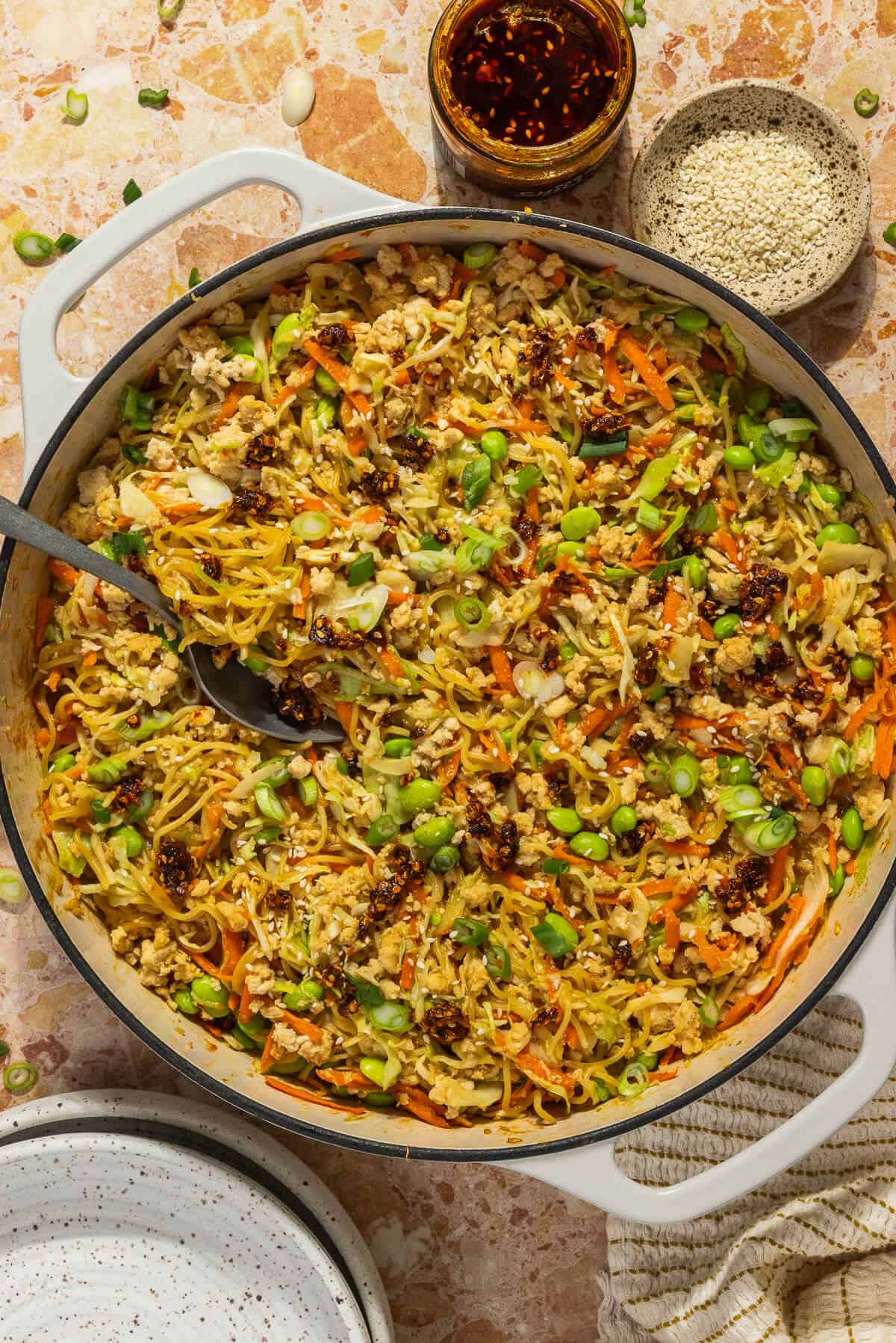 A large pan of one pan peanut chicken ramen topped with chili crisp.