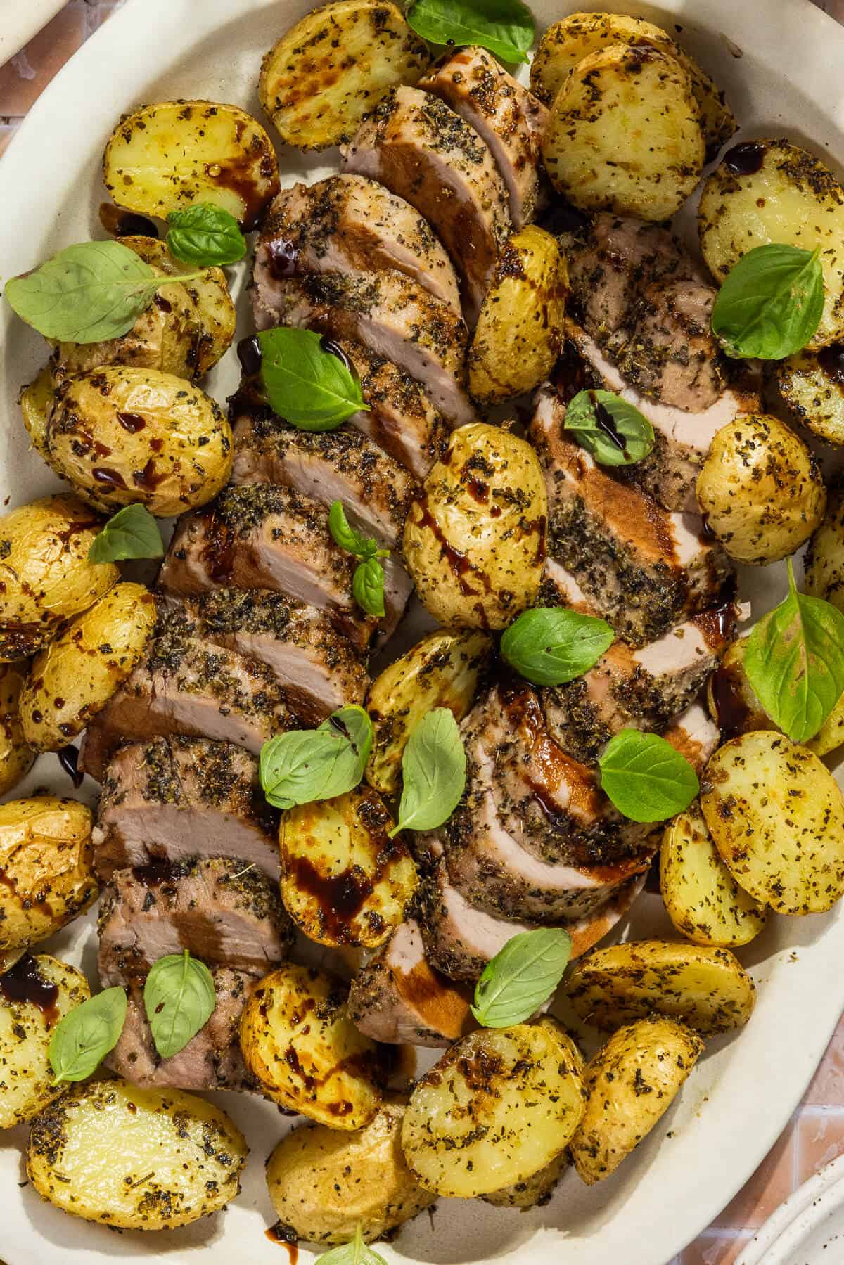 A close up shot of the sheet pan pork tenderloin drizzled with the balsamic glaze.