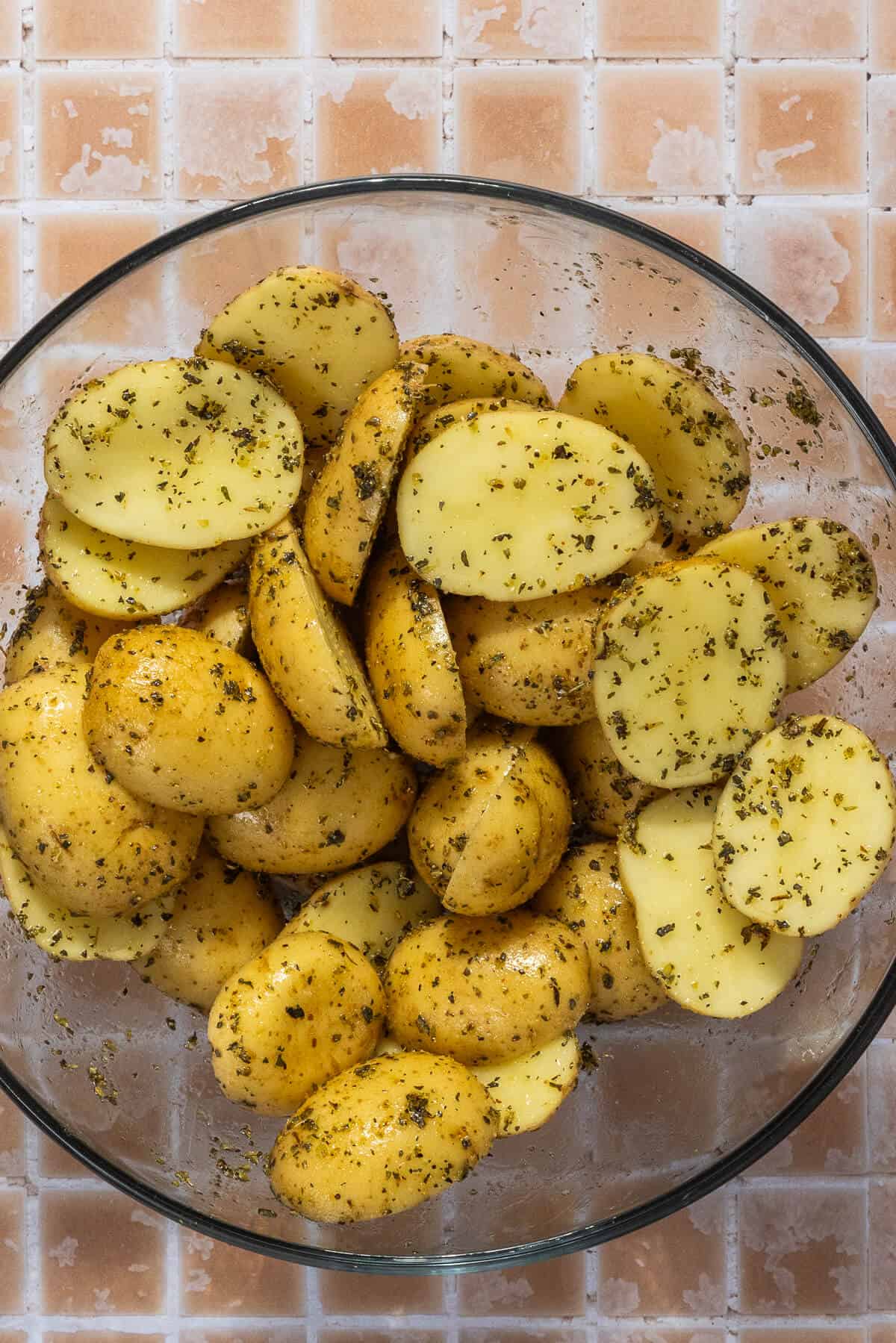 A mixing bowl with seasoned baby potatoes.