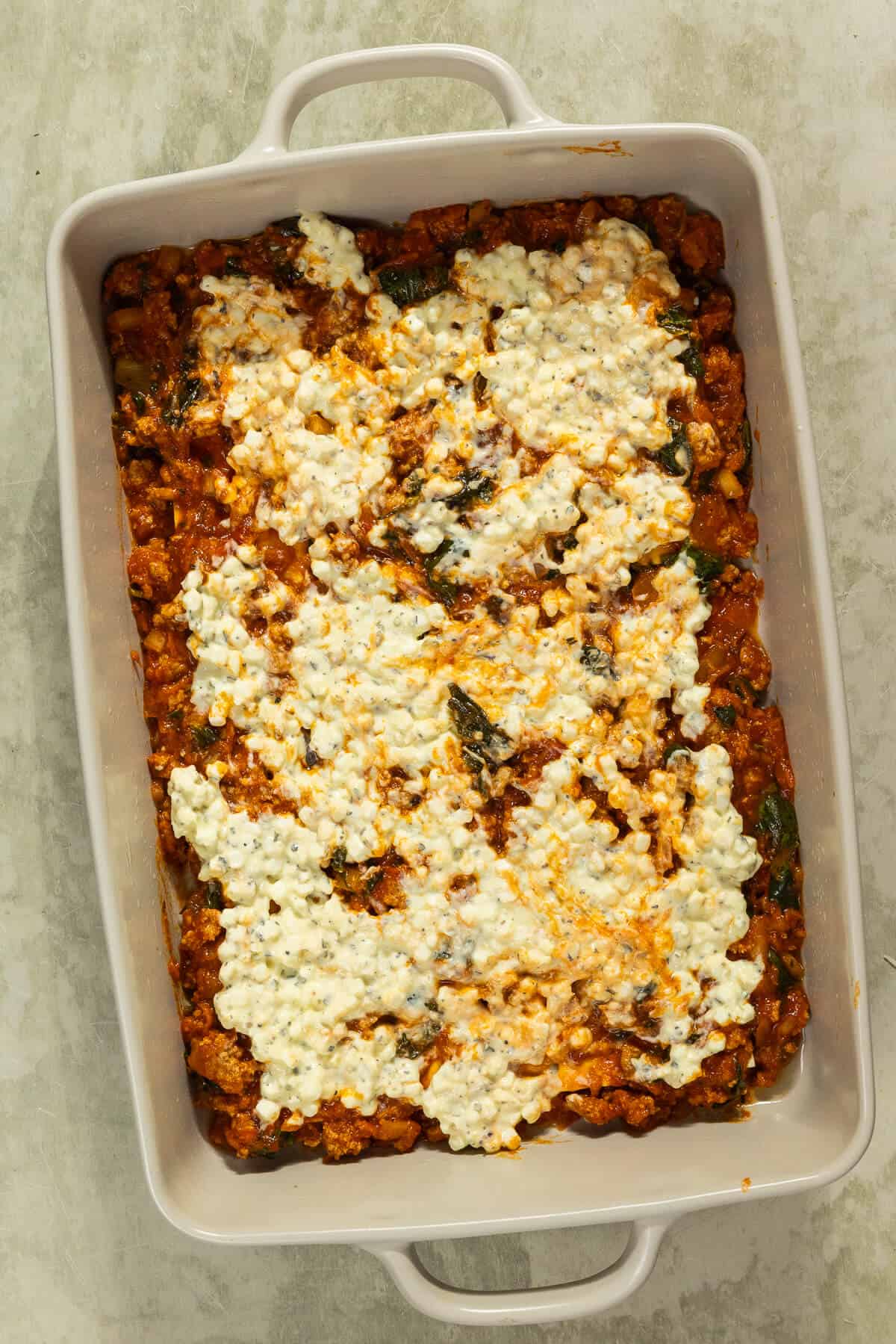 Cottage cheese spread on top of the meat mixture.