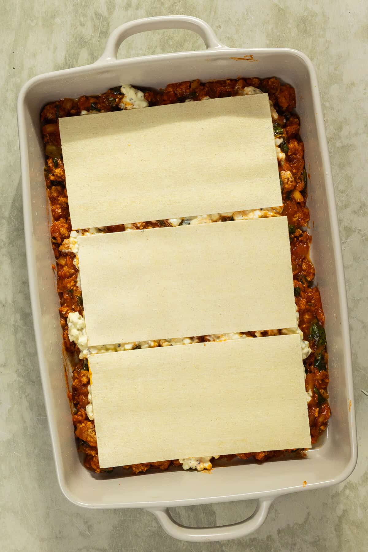 Lasagna noodles added on top of the cottage cheese and the meat mixture.