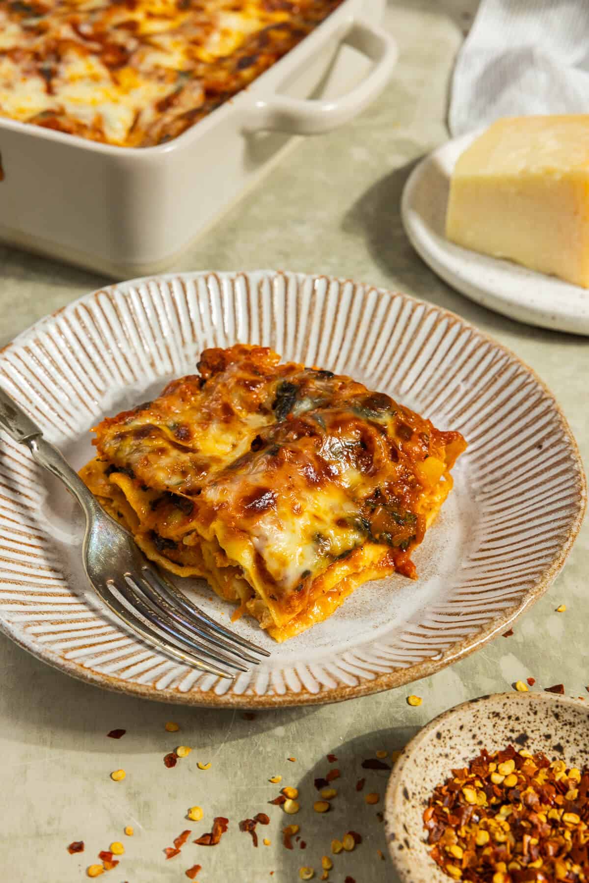 A piece of lasagna on a plate.