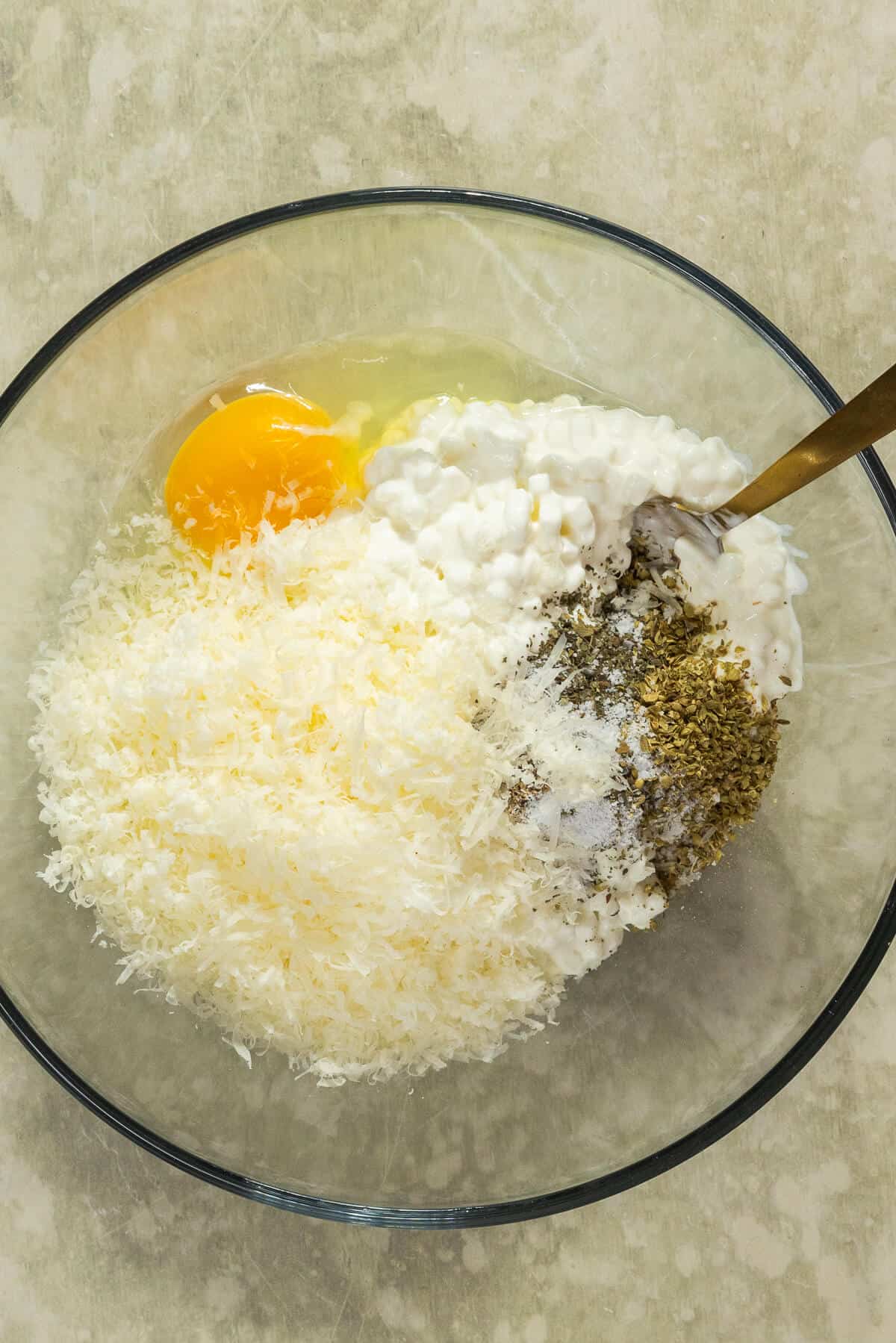 A mixing bowl with the ingredients for the cottage cheese mixture prior to being mixed.