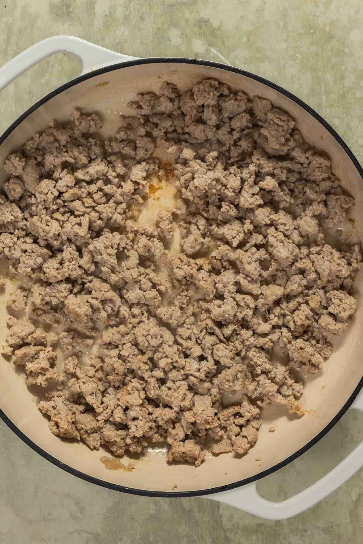 A large skillet with cooked ground turkey.