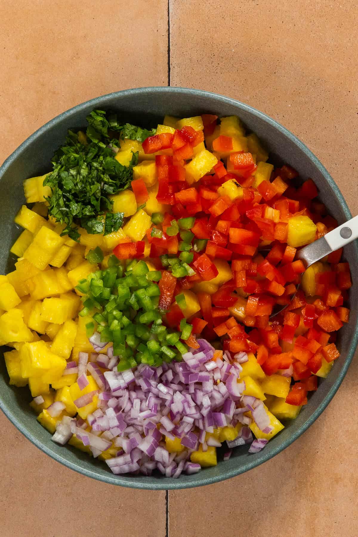 A bowl of ingredients for pineapple salsa before being mixed together.