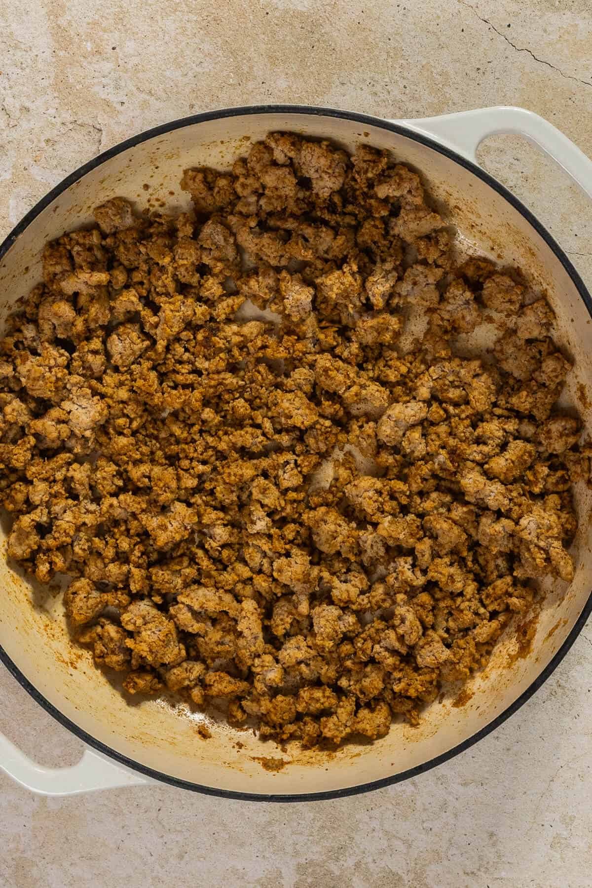 A large pan with cooked and seasoned ground turkey.