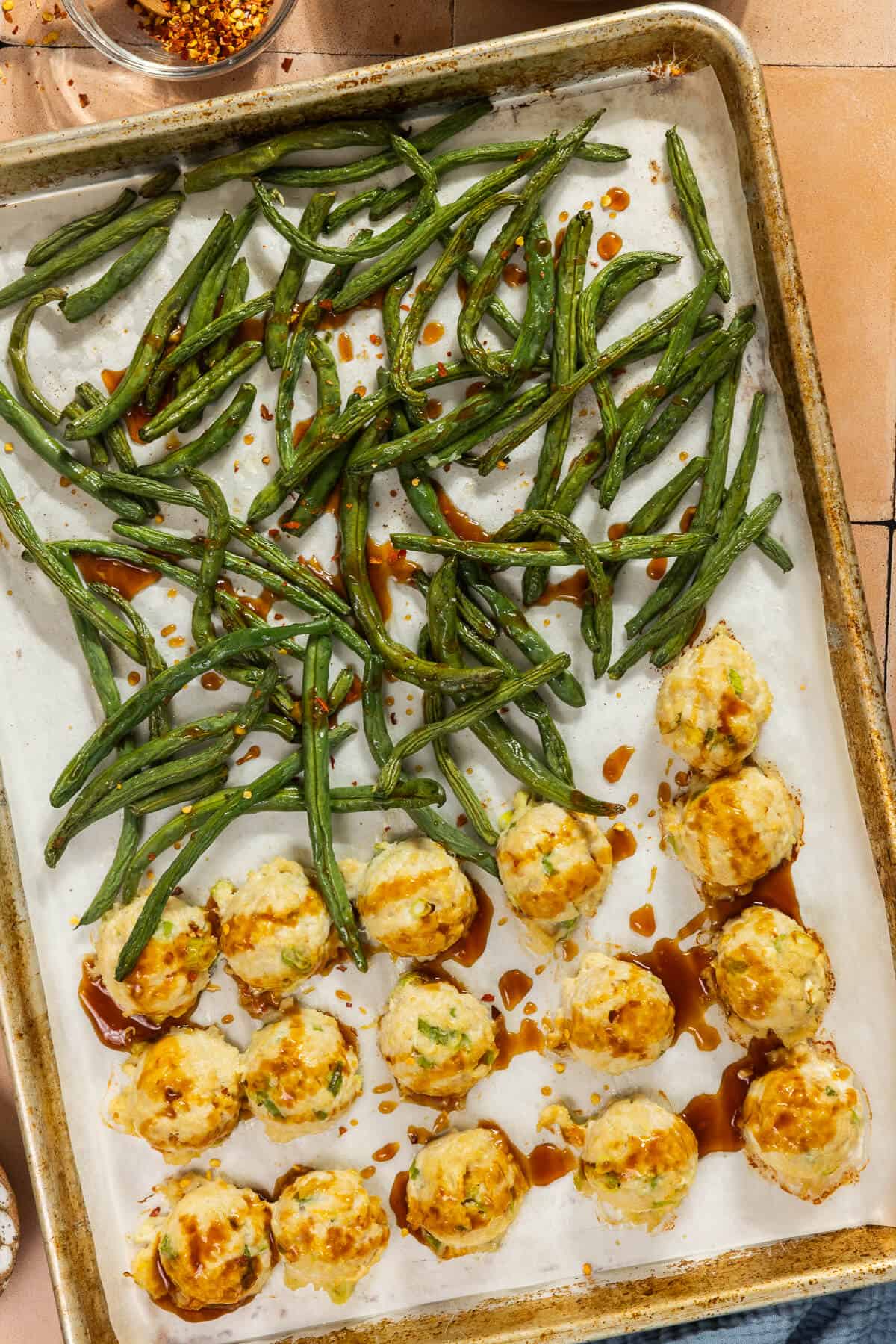 The baked chicken meatballs and green beans drizzled with the homemade sauce.