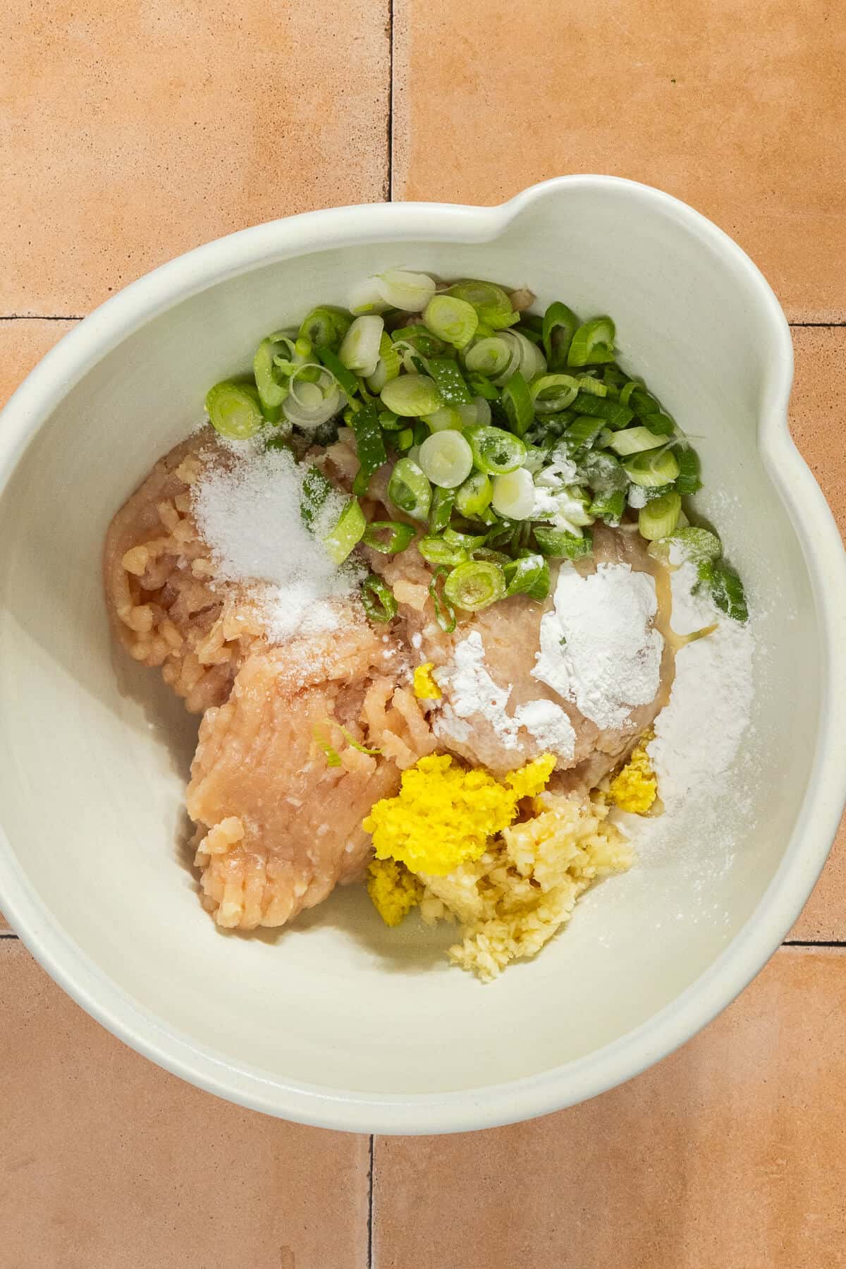 A mixing bowl with the ingredients for the baked chicken meatballs.