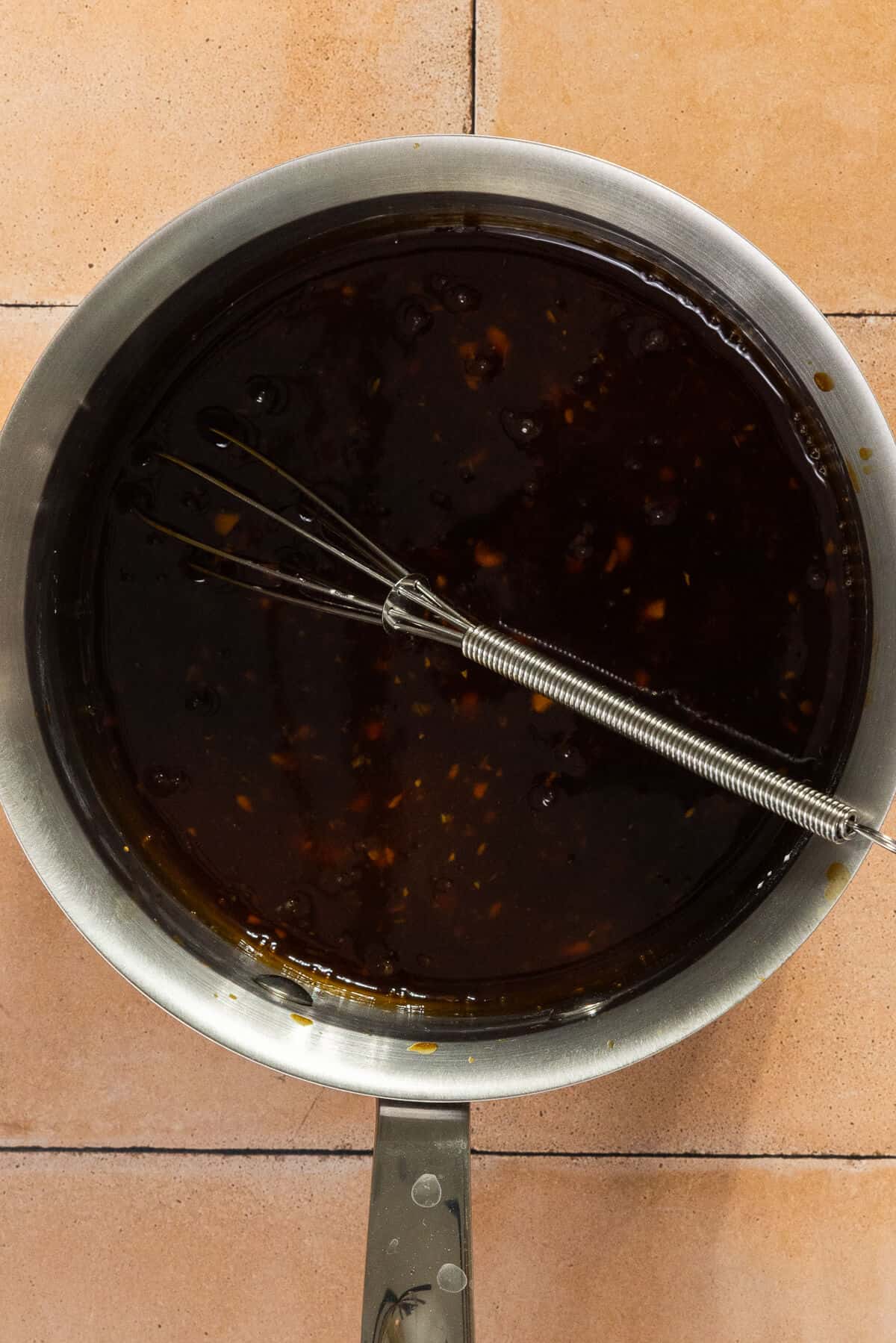 A saucepan with the ingredients for the homemade sauce for the chicken meatballs and green beans.