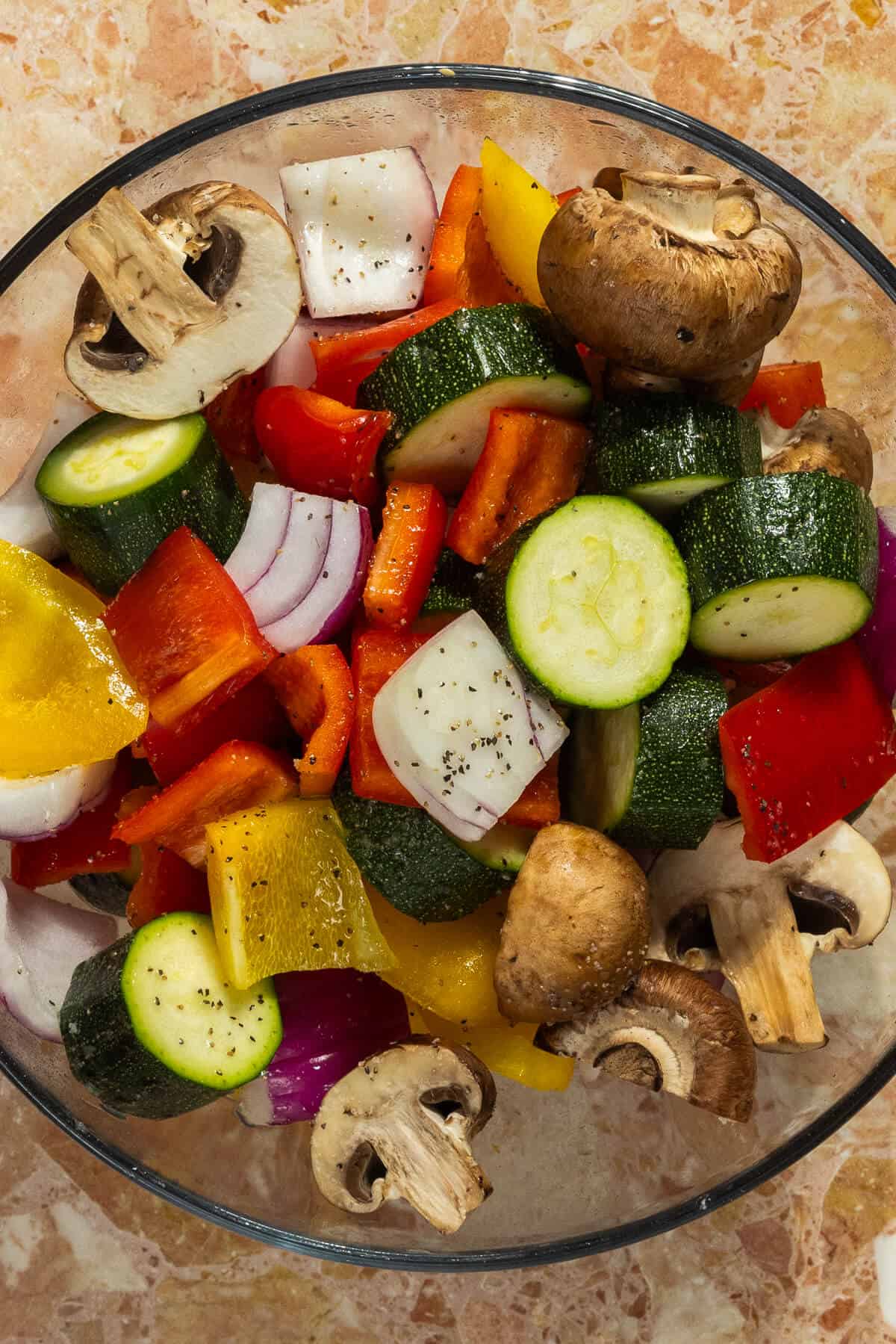 A large mixing bowl with the prepared vegetables for the beef kabobs.