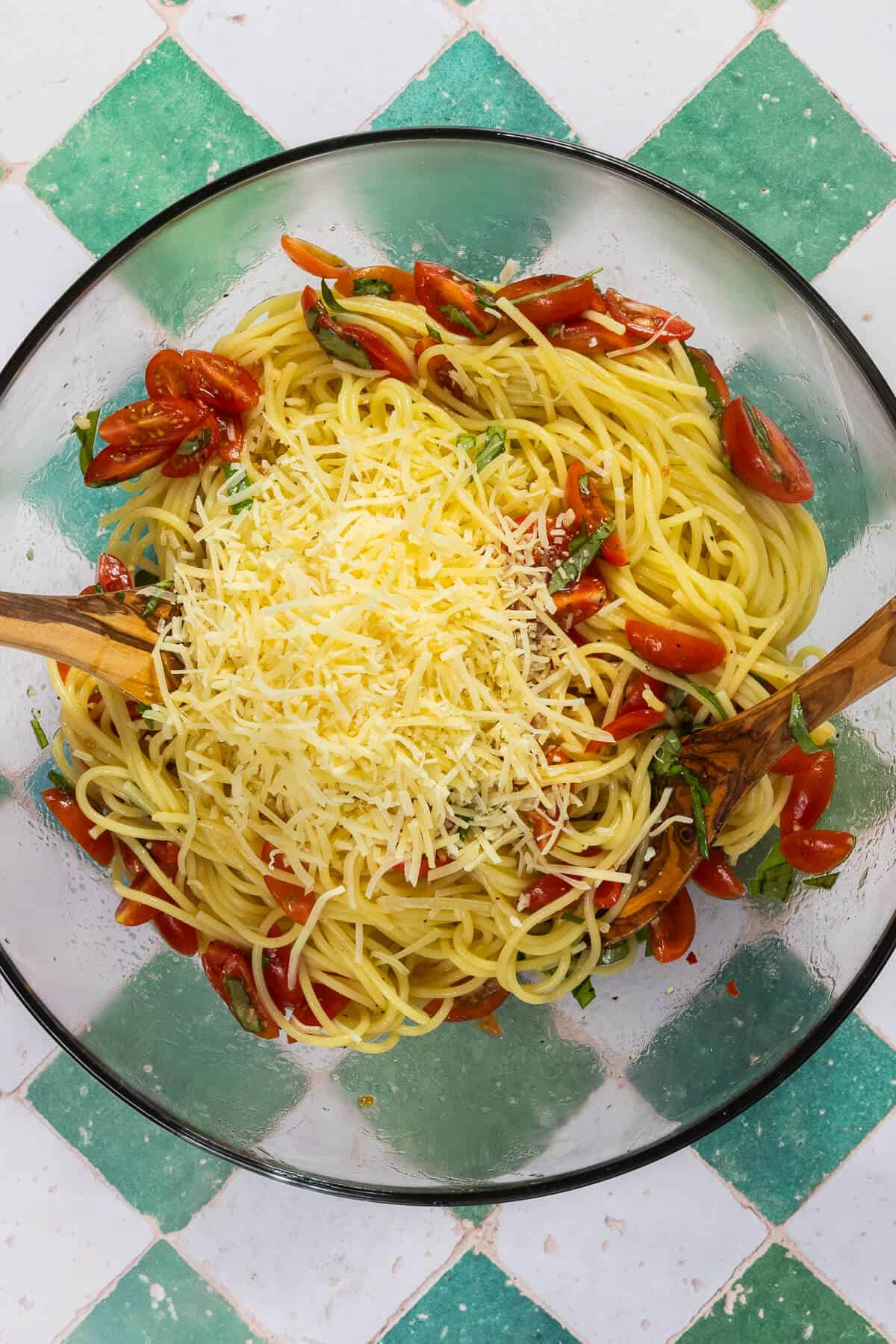 A large mixing bowl with parmesan cheese added to the bruschetta pasta.