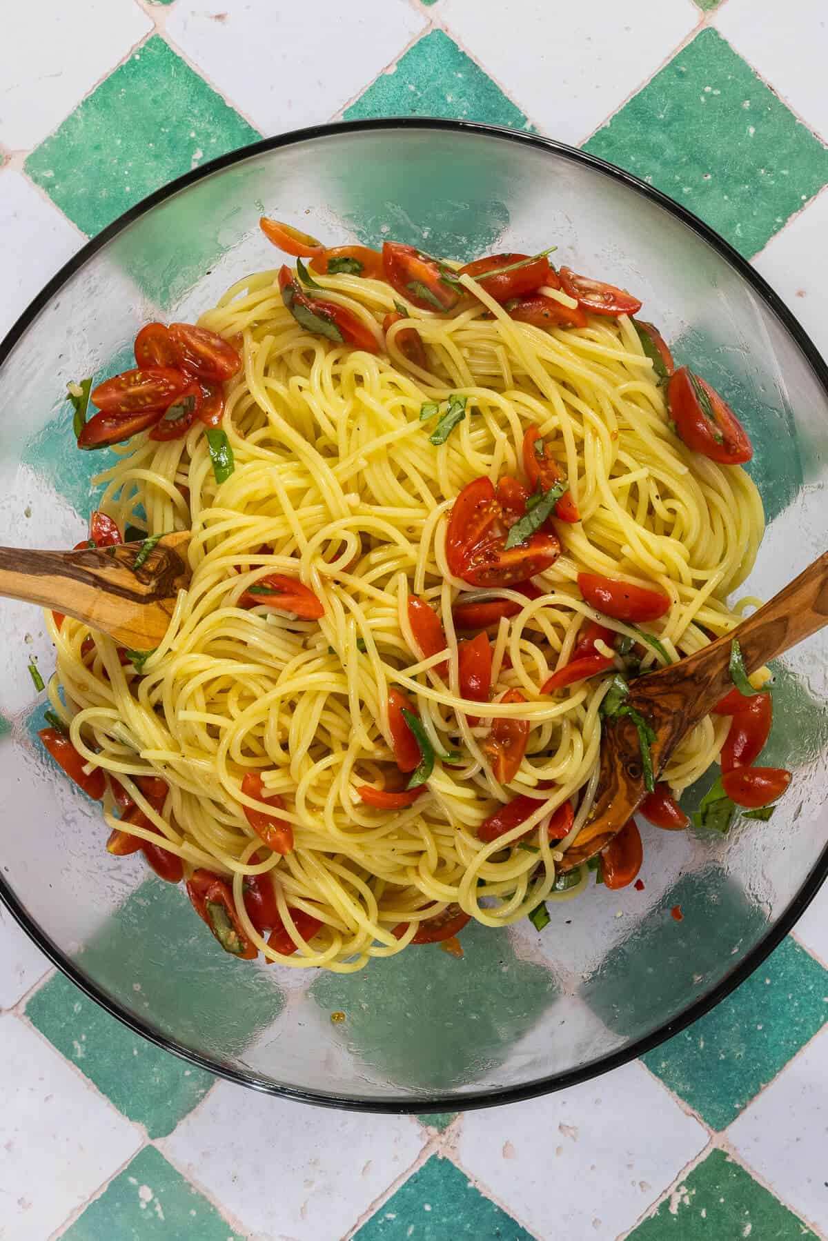 A large mixing bowl with the bruschetta pasta ingredients combined together.