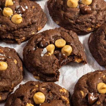 Chocolate and peanut butter chip cookies with a bite taken out of one.