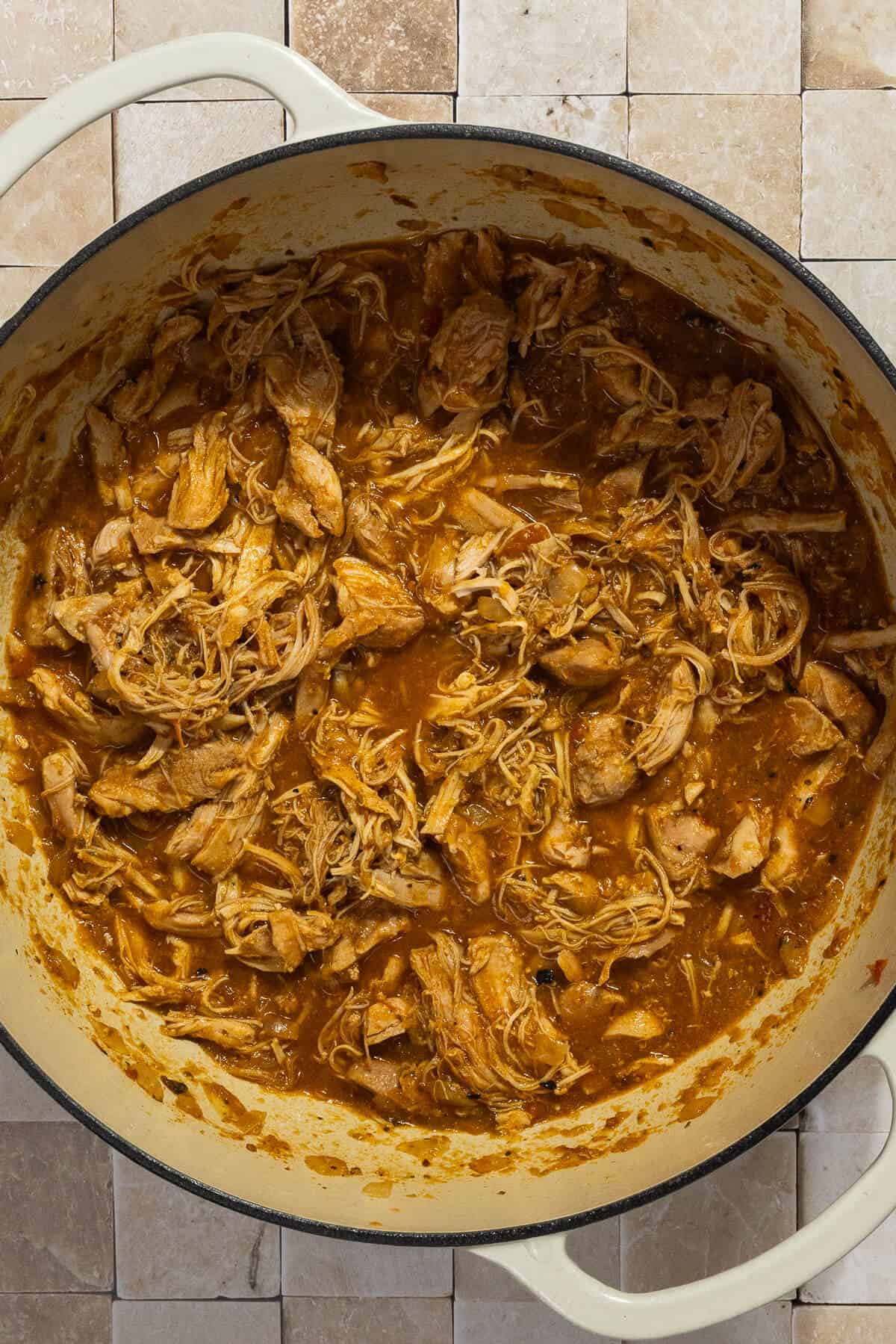 A large pot of shredded dutch oven chicken thighs.