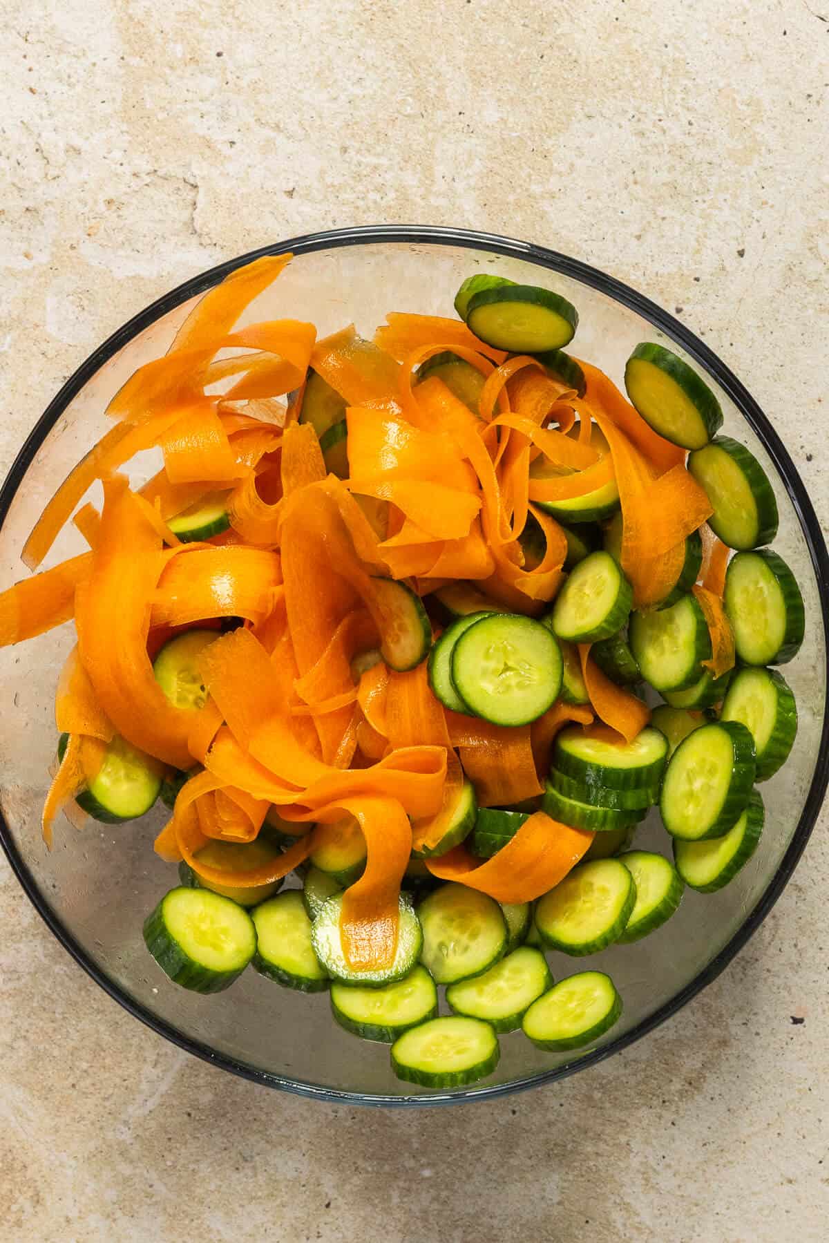 A mixing bowl with the cucumber and carrot salad.
