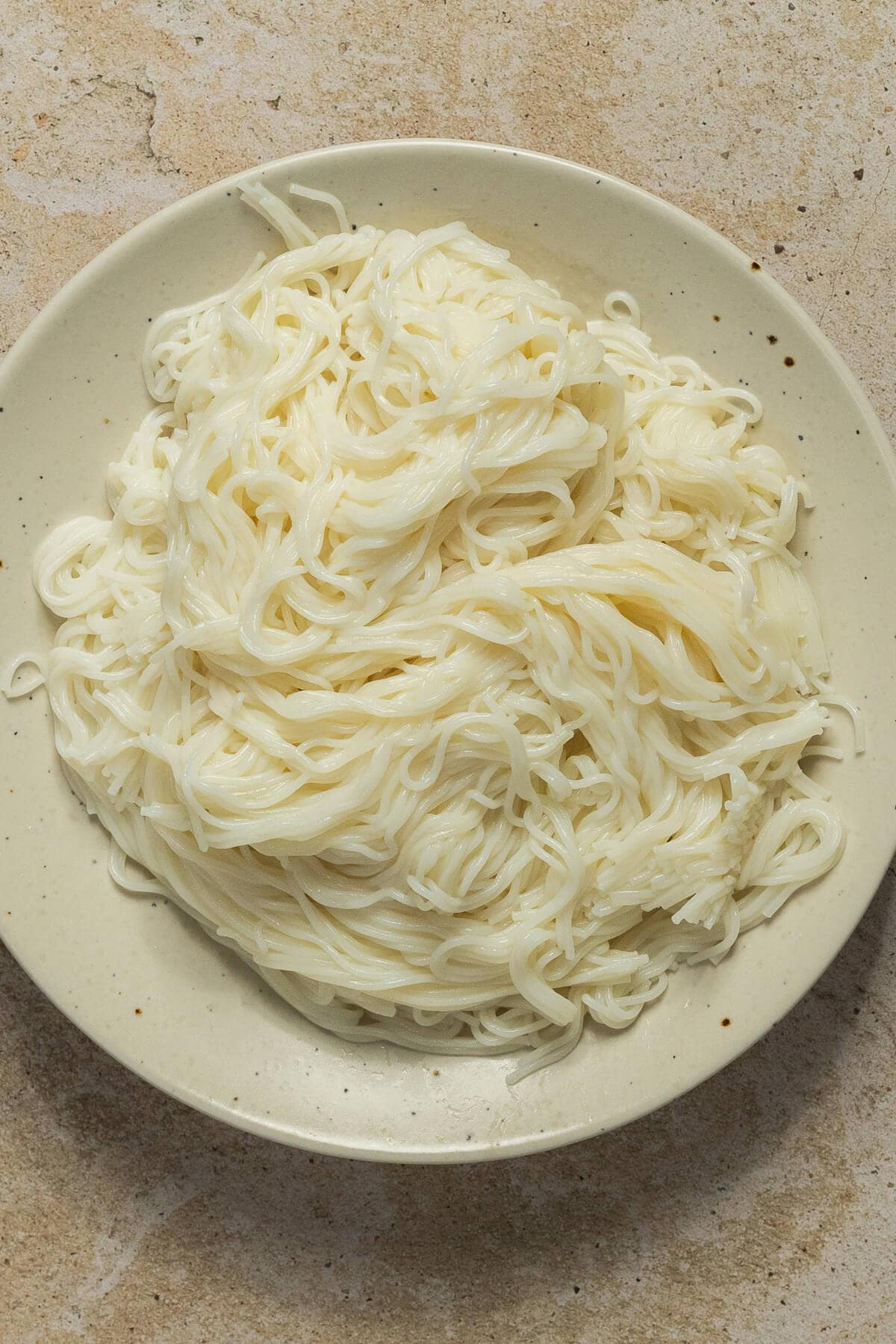 A bowl of cooked rice noodles.