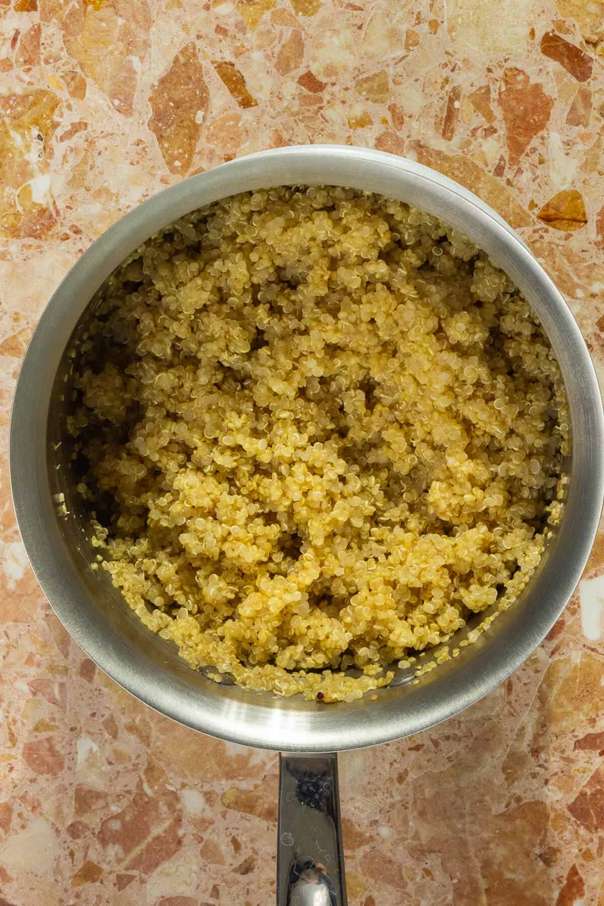 A small saucepan with cooked quinoa.