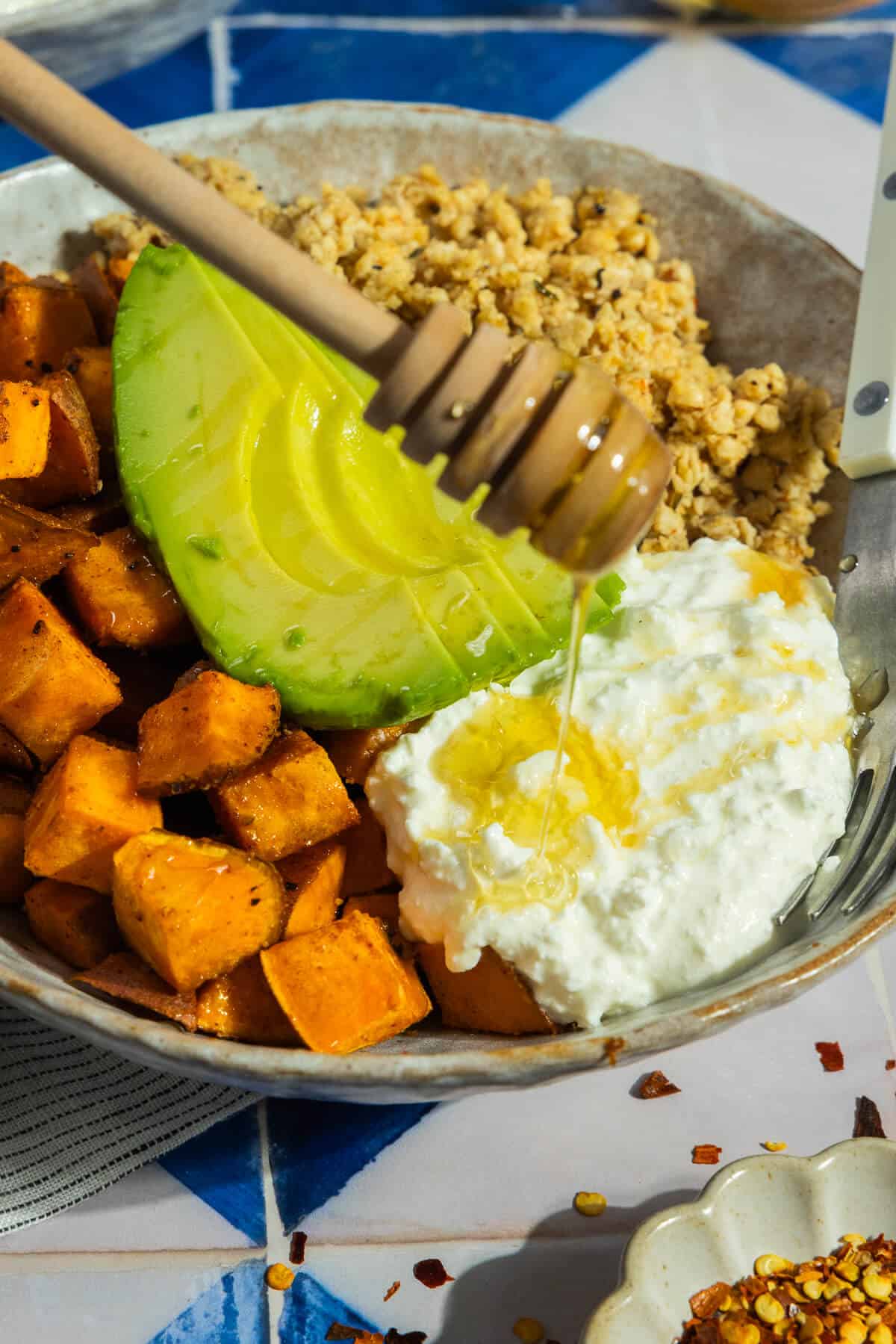 Hot honey being drizzle onto a breakfast bowl.