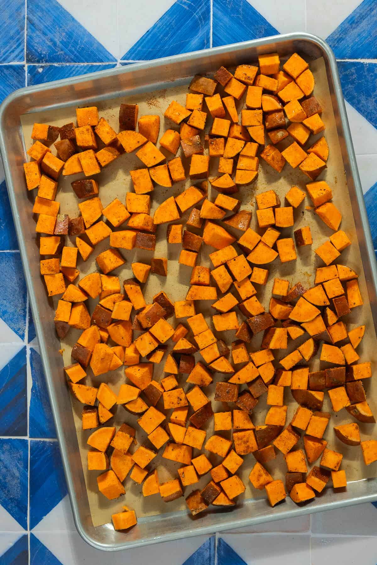 A baking sheet with diced sweet potatoes.