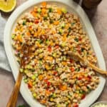 A large platter with the prepared white bean salad and tongs.