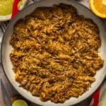 A large pot of shredded slow cooker pork carnitas.