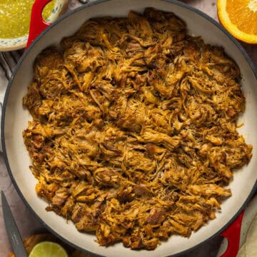 A large pot of shredded slow cooker pork carnitas.