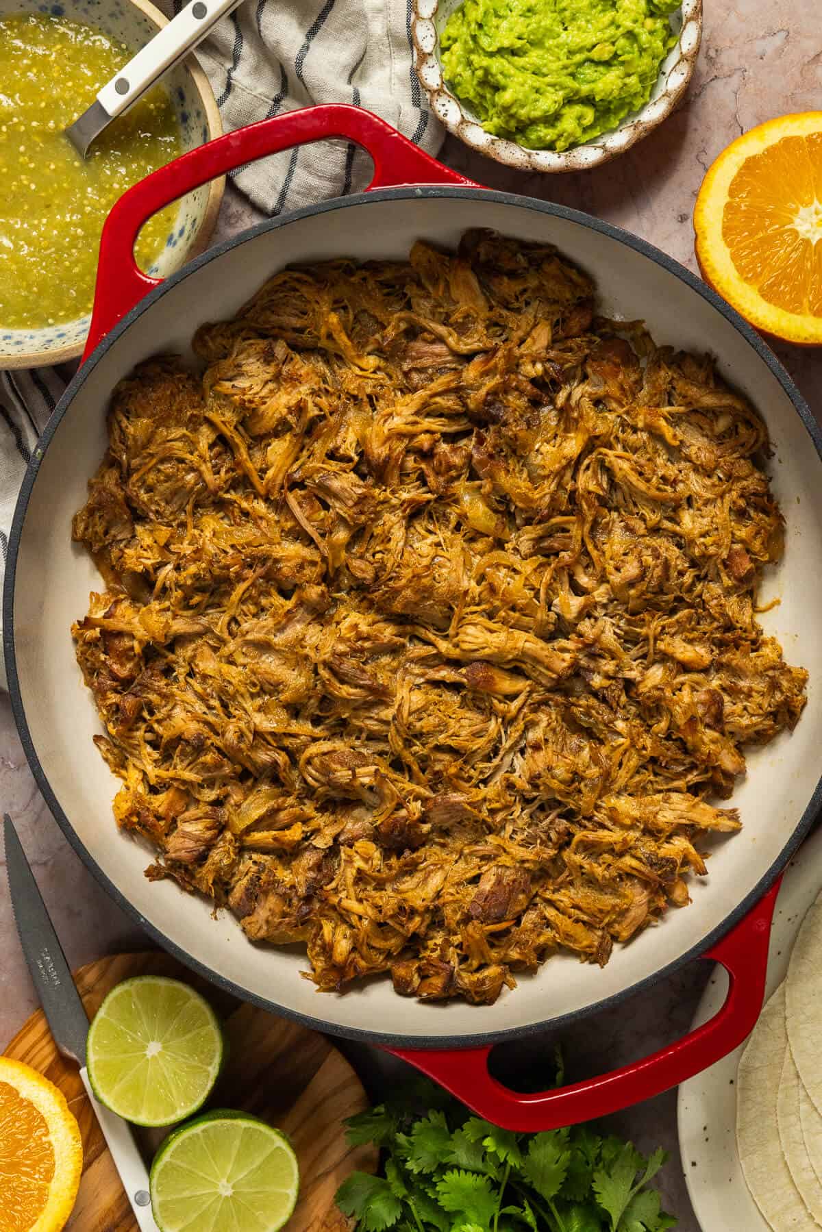 A large pot of shredded slow cooker pork carnitas.