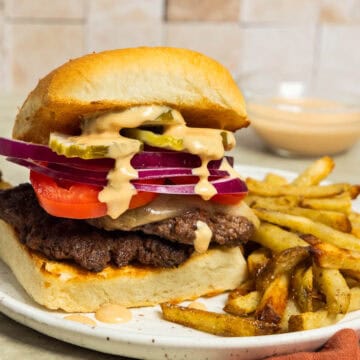A plate with a homemade smashburger and French fries.