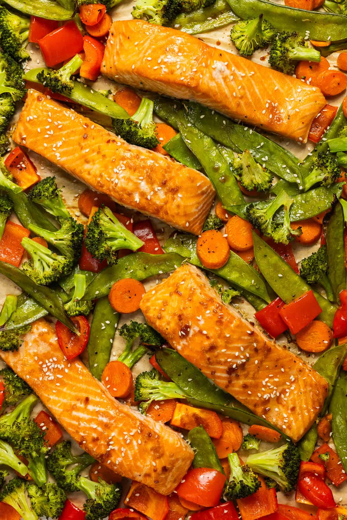A sheet pan with cooked teriyaki salmon and veggies.