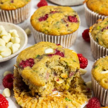 White chocolate raspberry muffin with a bite taken out of it.