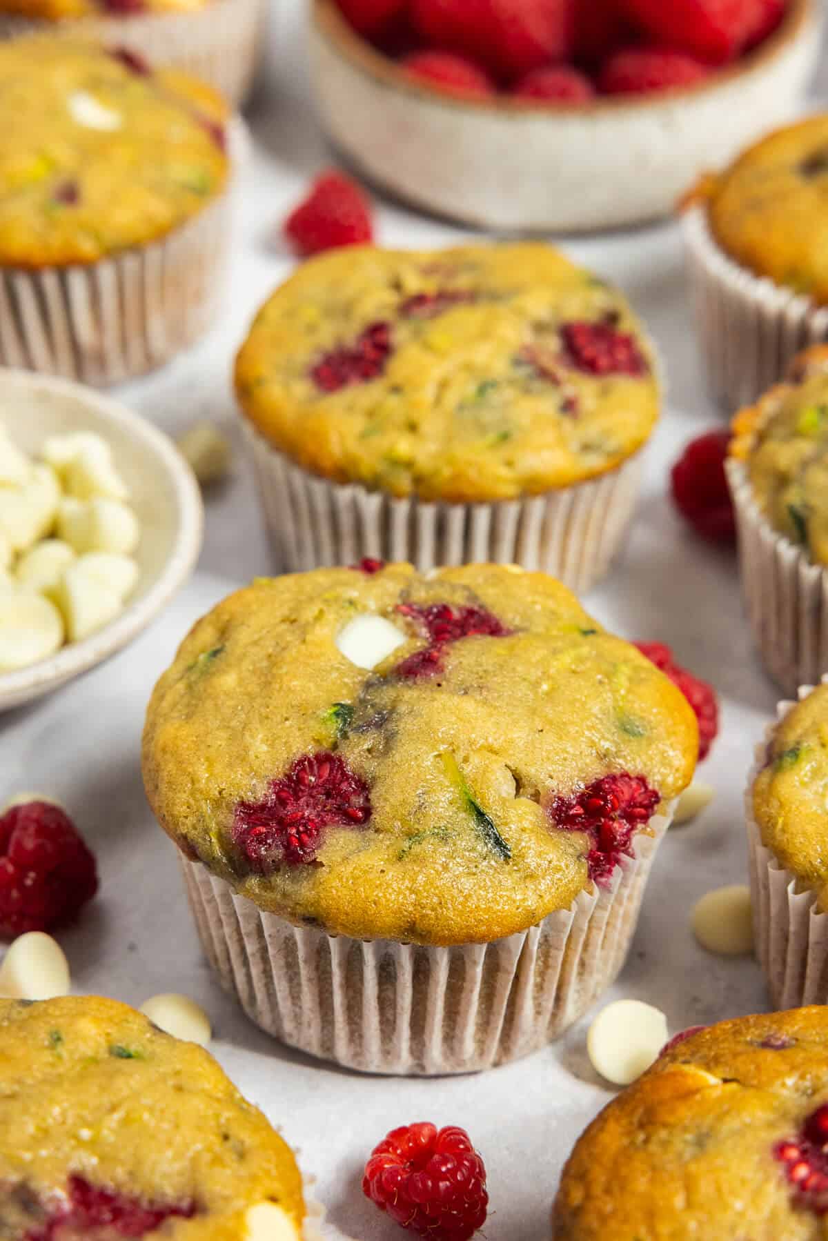 White chocolate raspberry muffins with one in focus.