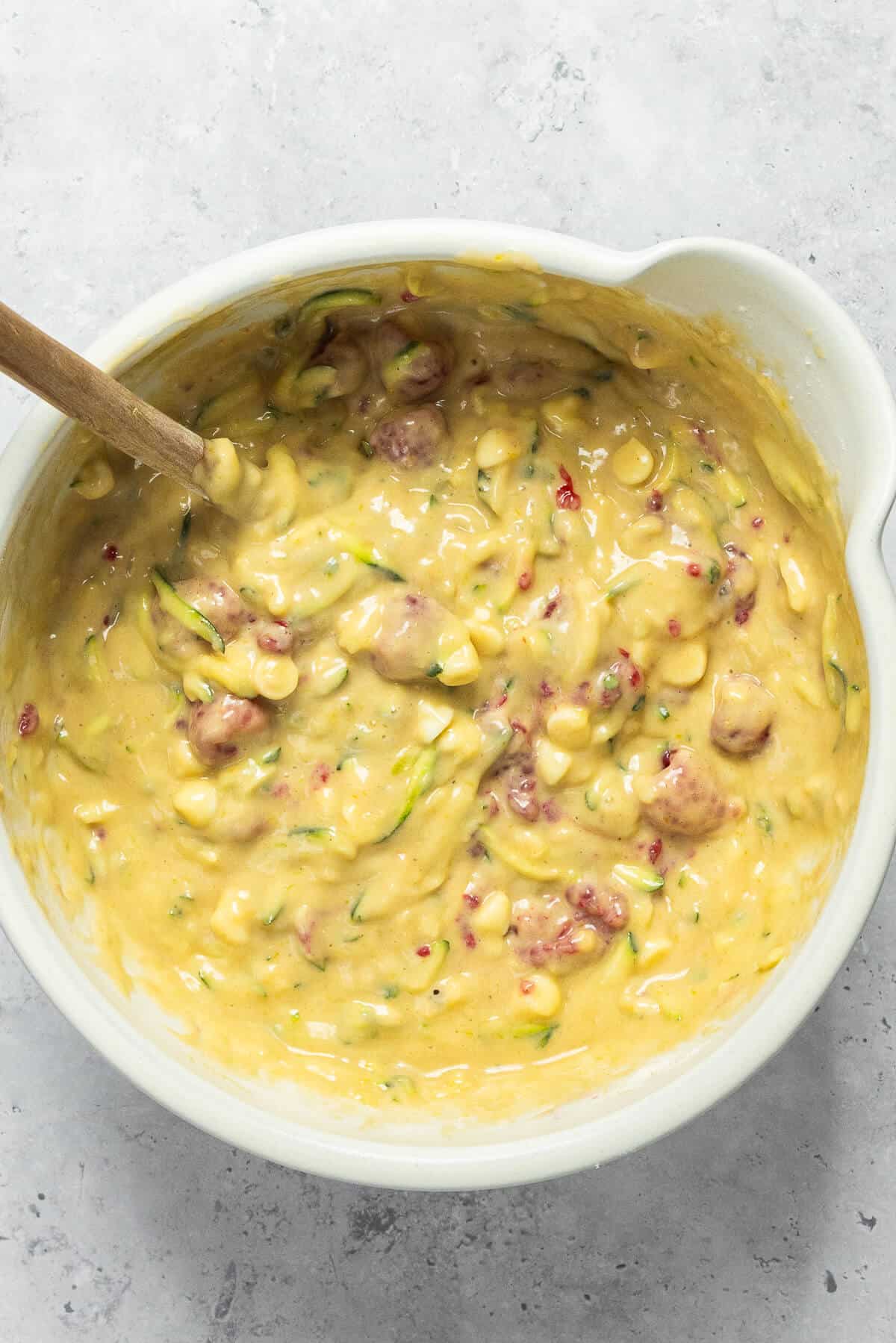 A large mixing bowl with all ingredients combined to make the muffin batter.