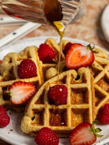 Oat protein waffles with syrup being poured on.