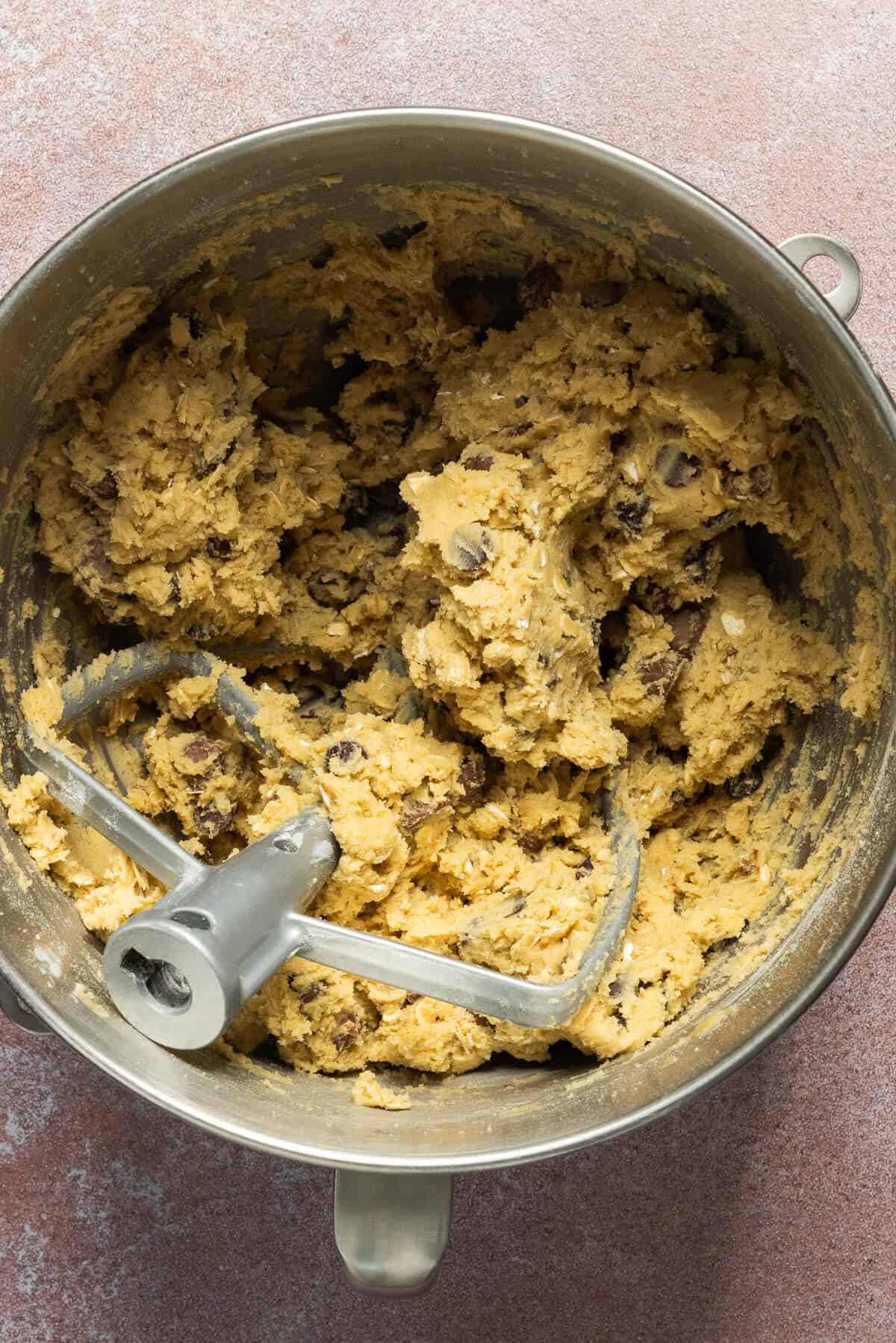 A mixing bowl with oatmeal chocolate chip cookie dough.