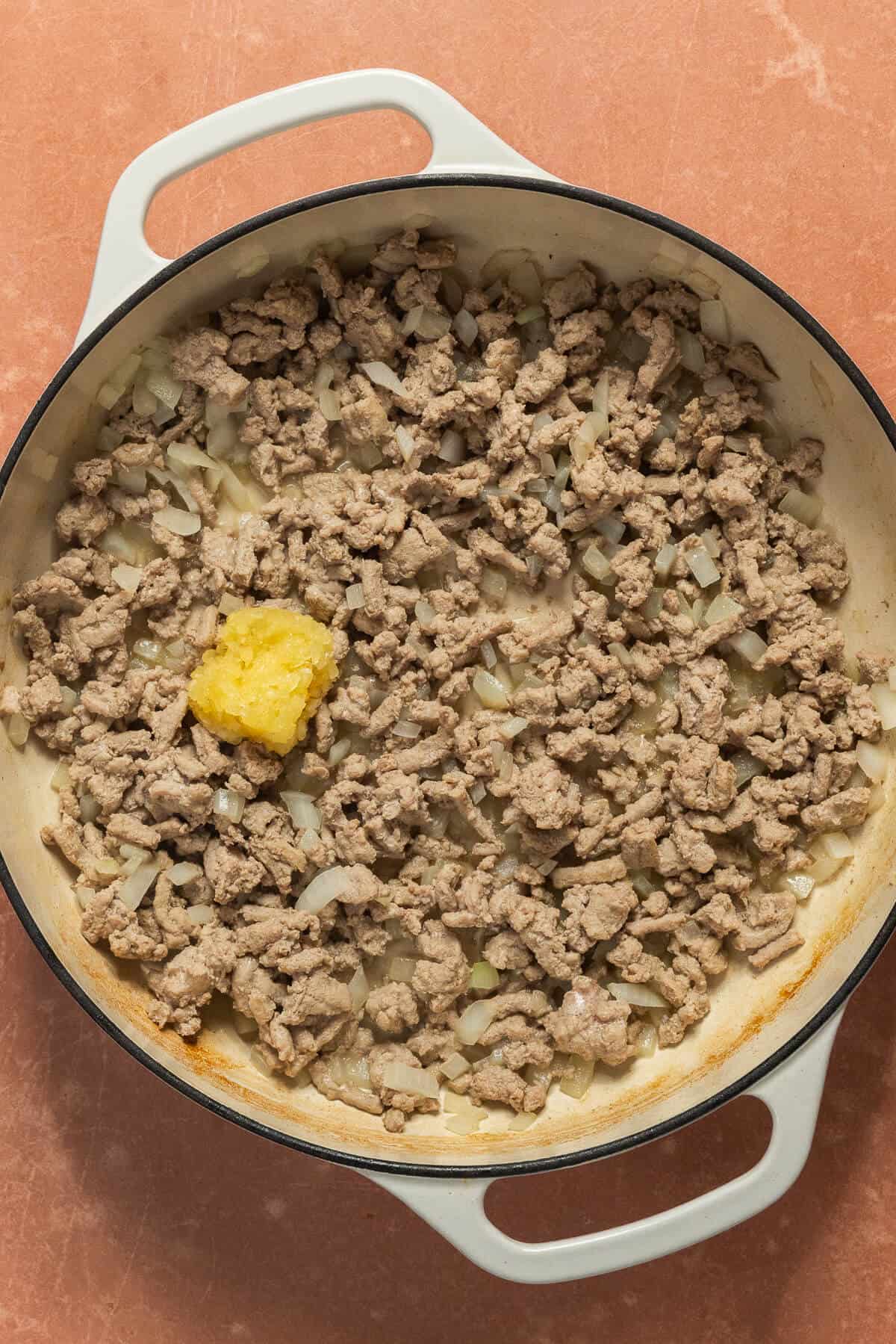 Garlic added to the skillet with onion and chicken sausage.