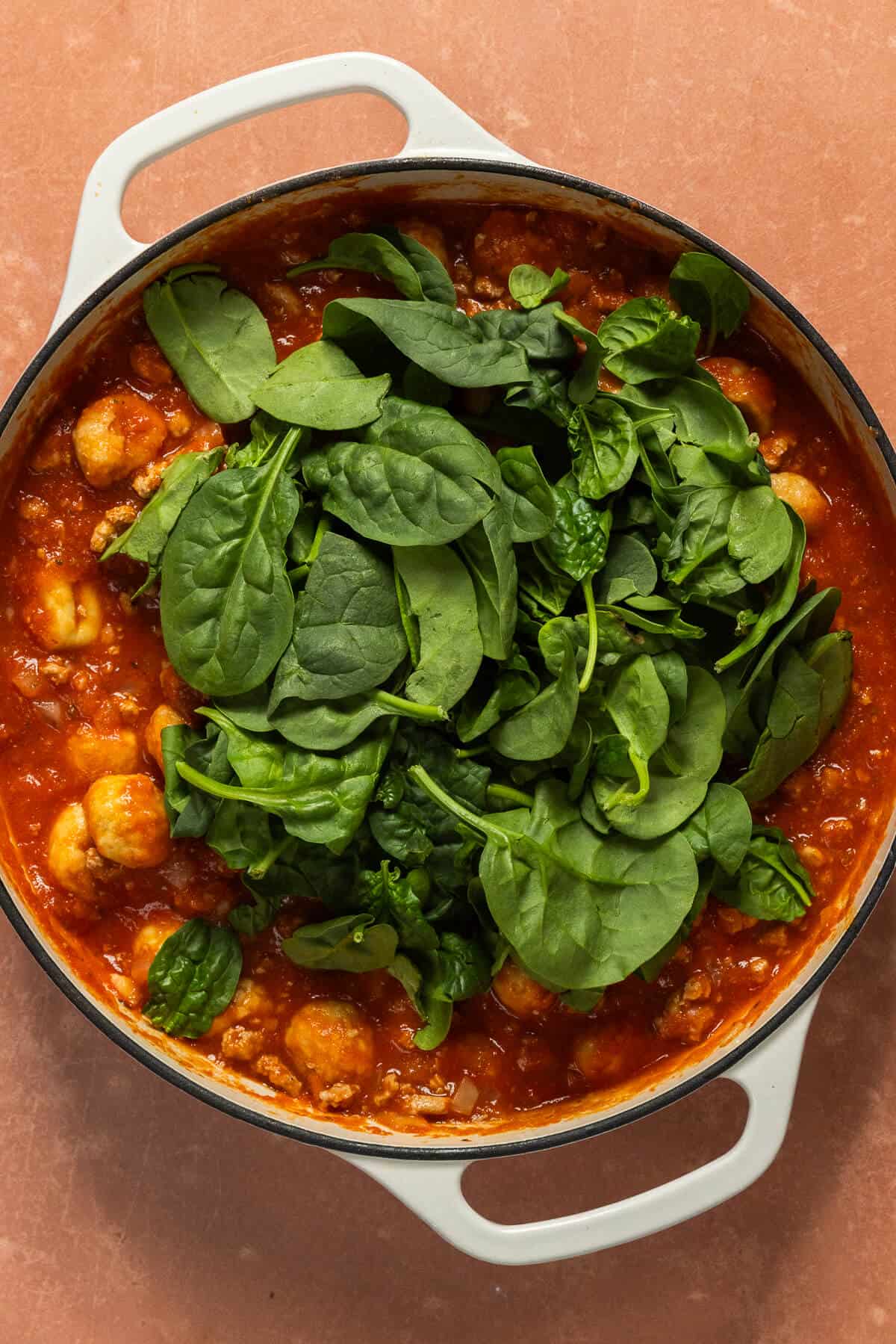 Spinach added to the skillet for the one pan gnocchi.