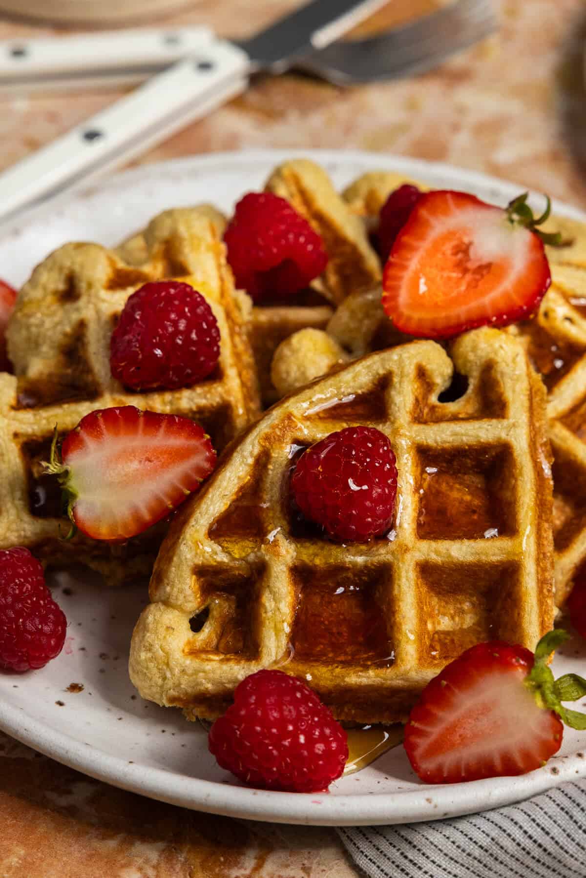 Delicious waffles topped with strawberries and raspberries for a nutritious breakfast.