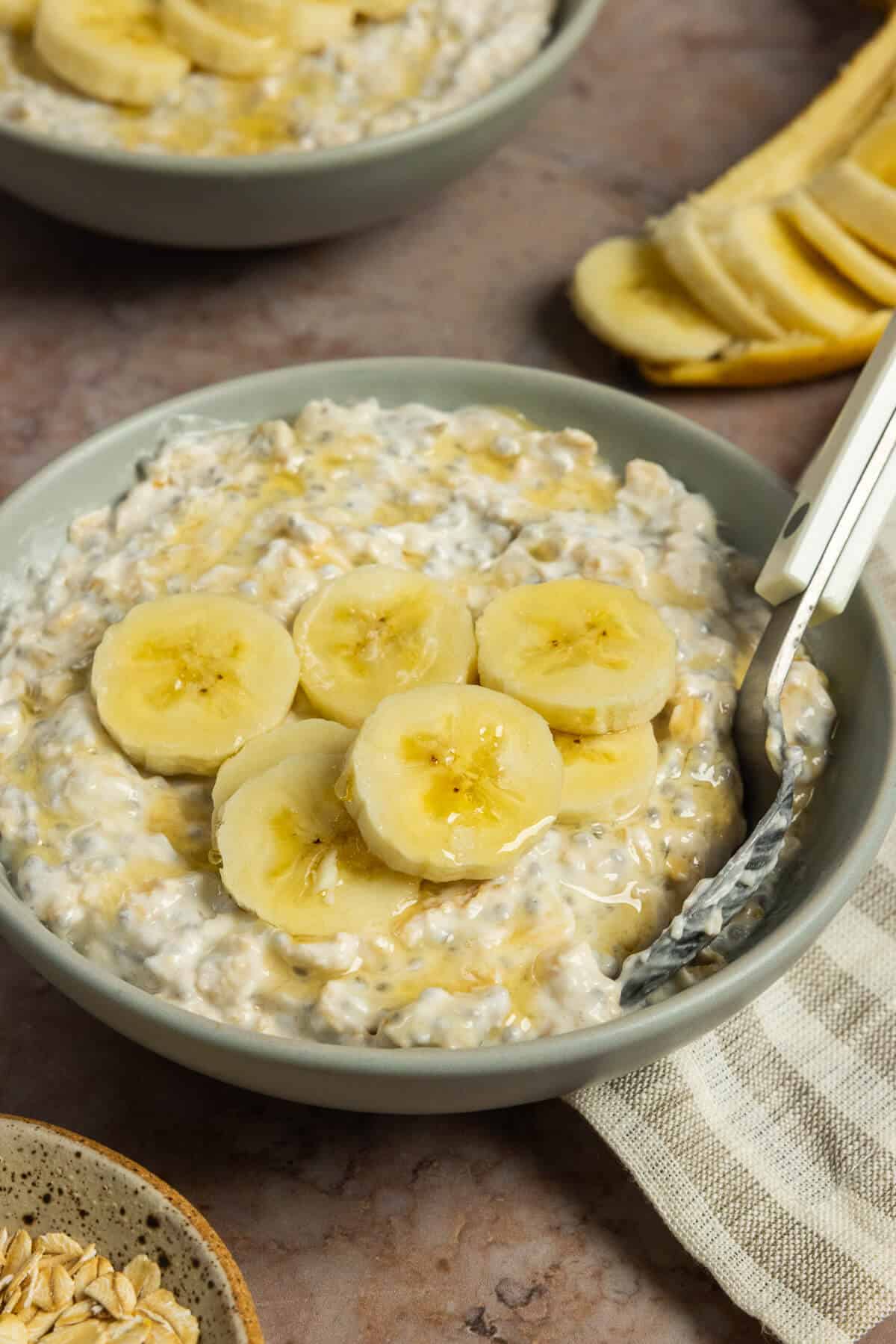 A bowl of banana overnight oats topped with sliced bananas.