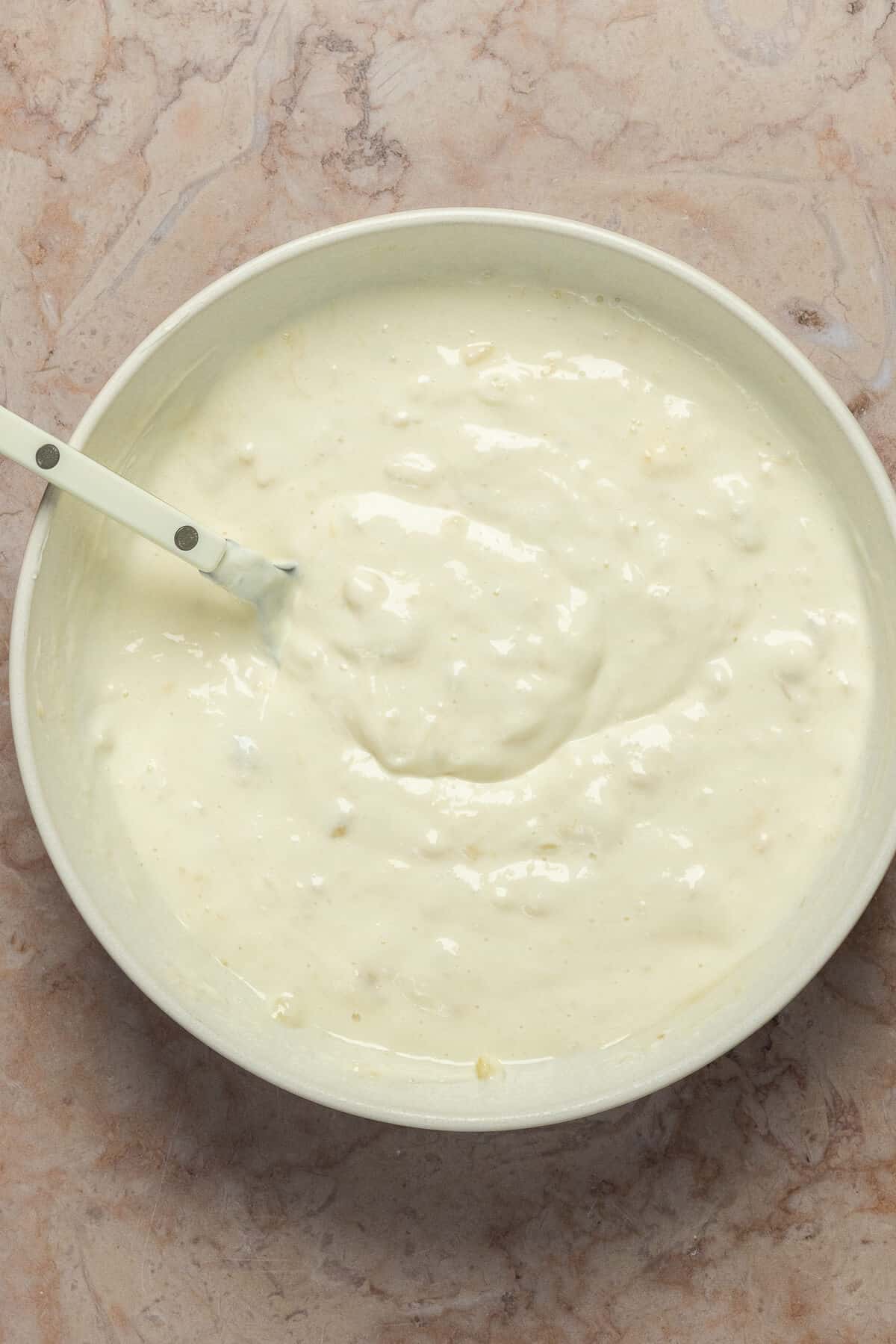 A mixing bowl with ingredients for banana overnight oats combined together.