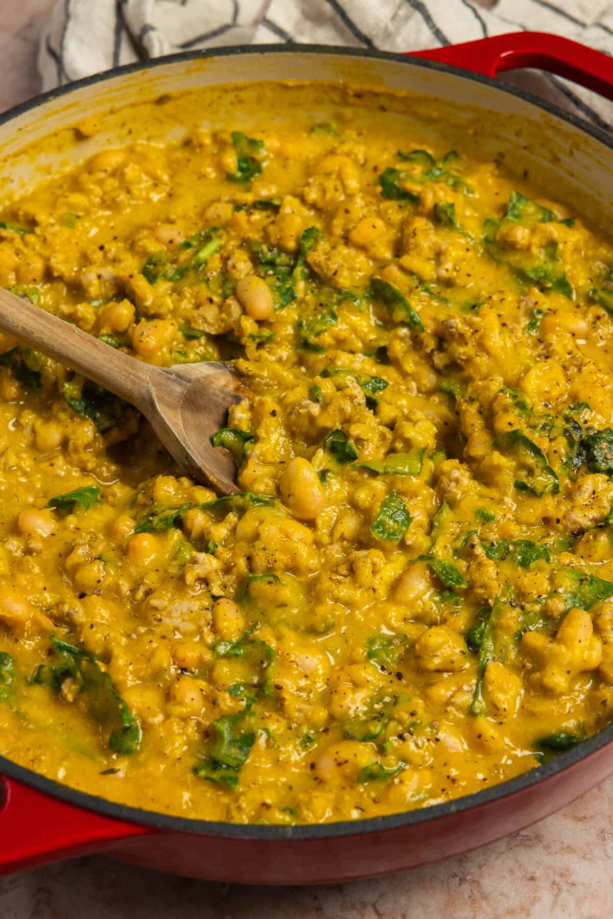 A spoon mixing the butternut squash skillet.