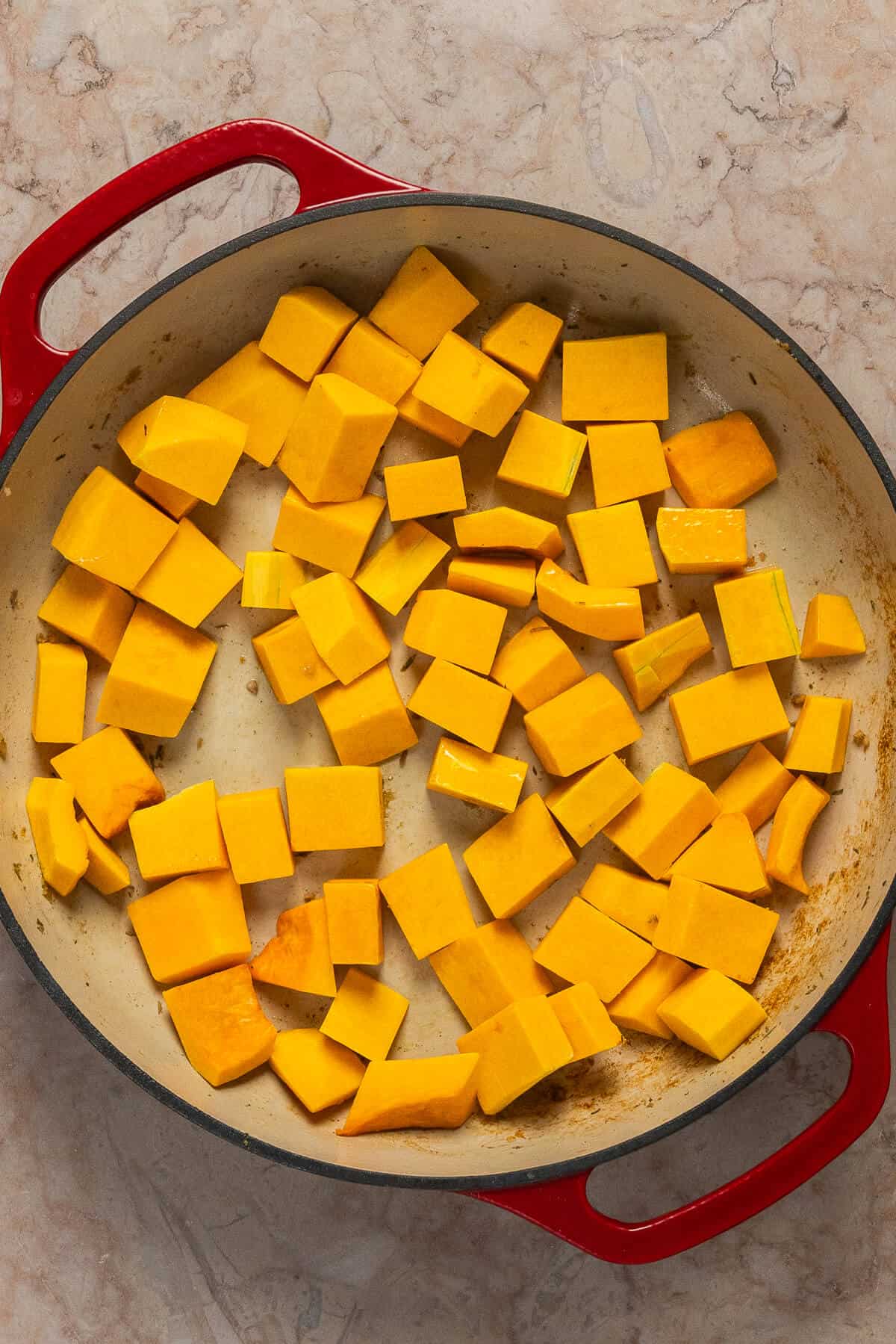 A large skillet with diced butternut squash.