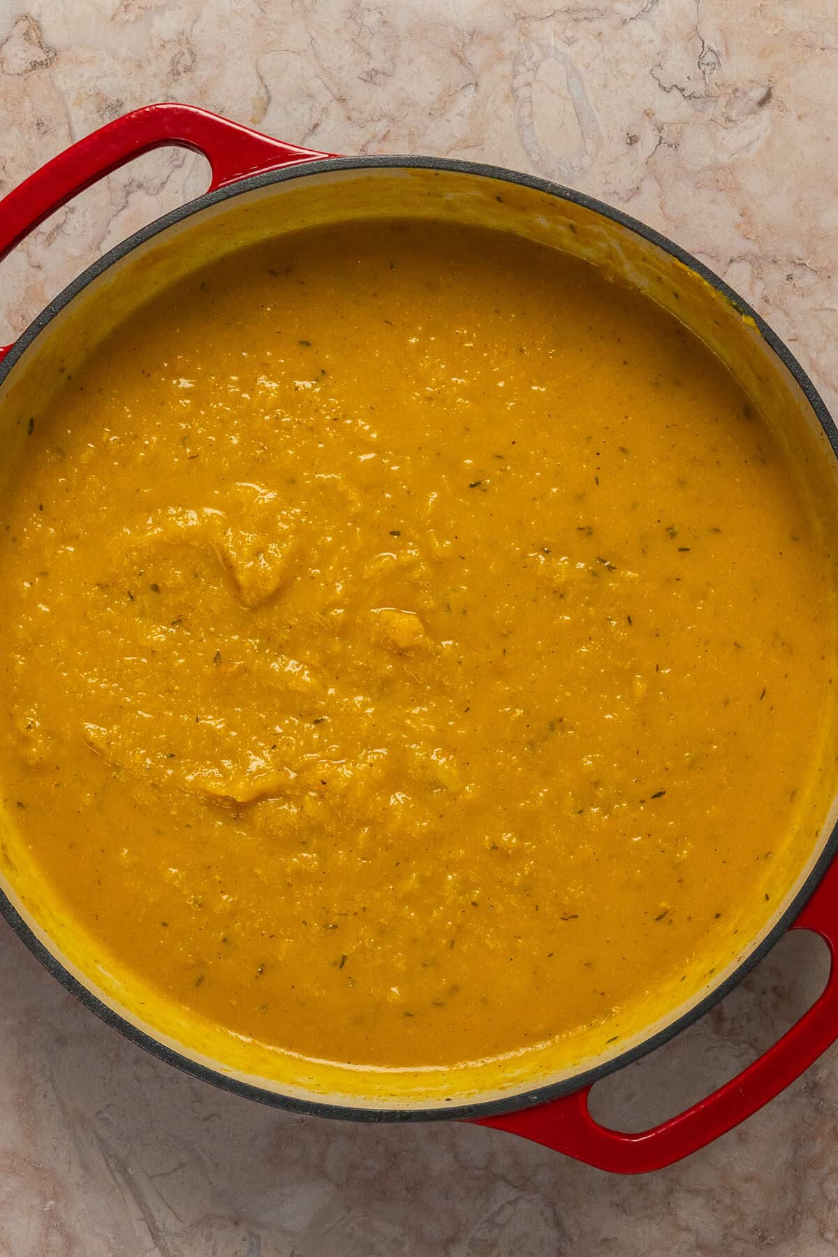 A large skillet with pureed butternut squash and spices.
