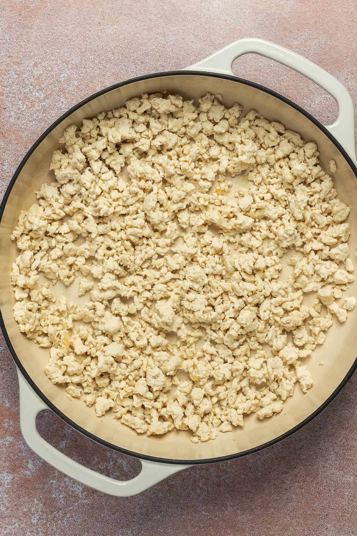 A large skillet with cooked ground chicken.