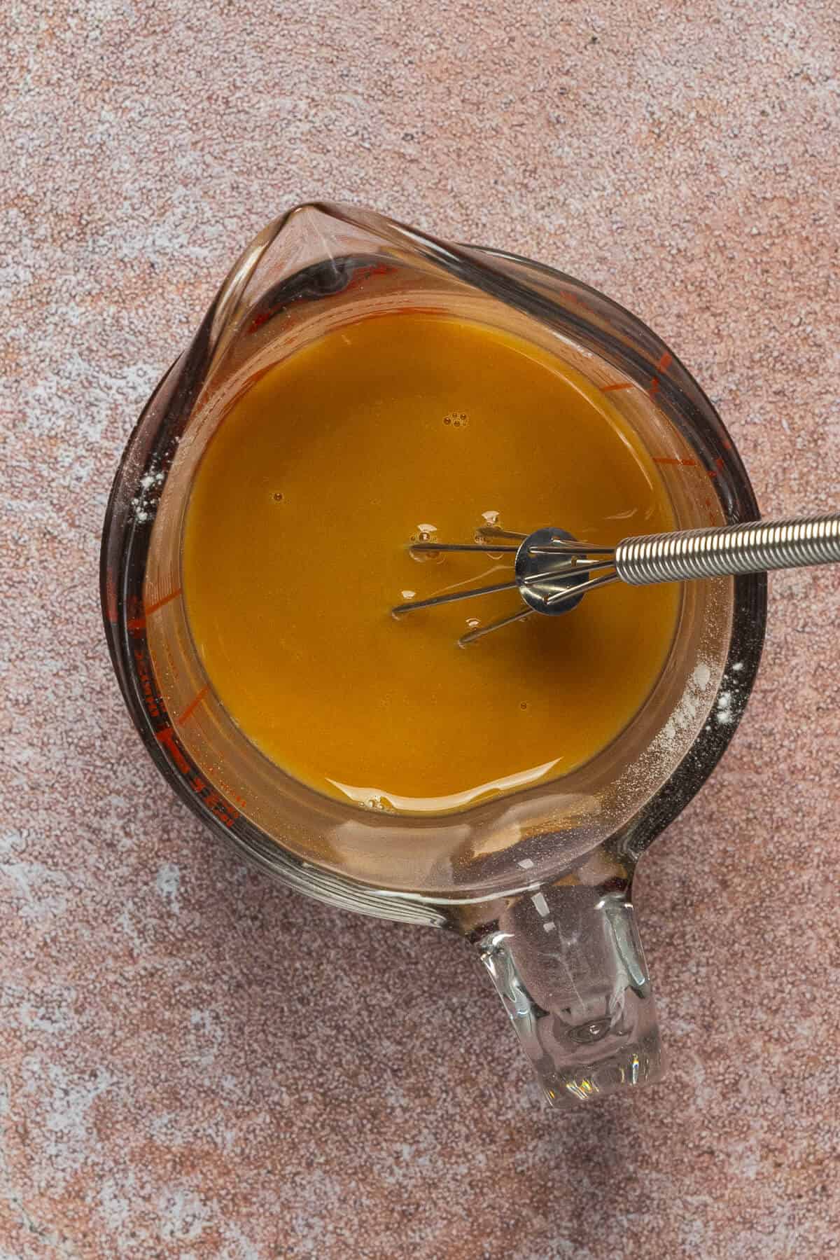 A pyrex measuring glass with the sauce ingredients whisked together for the ground meat.