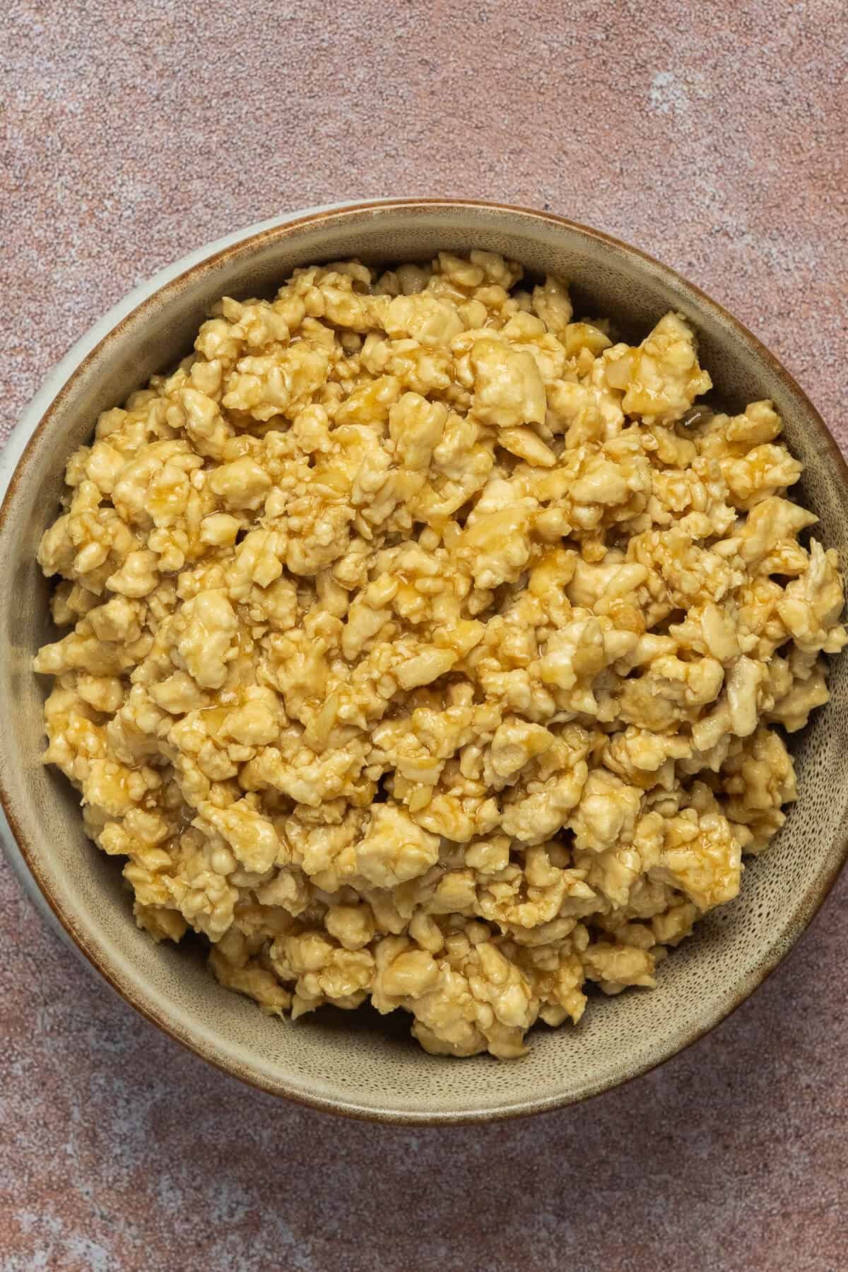 A bowl of cooked and seasoned ground chicken.